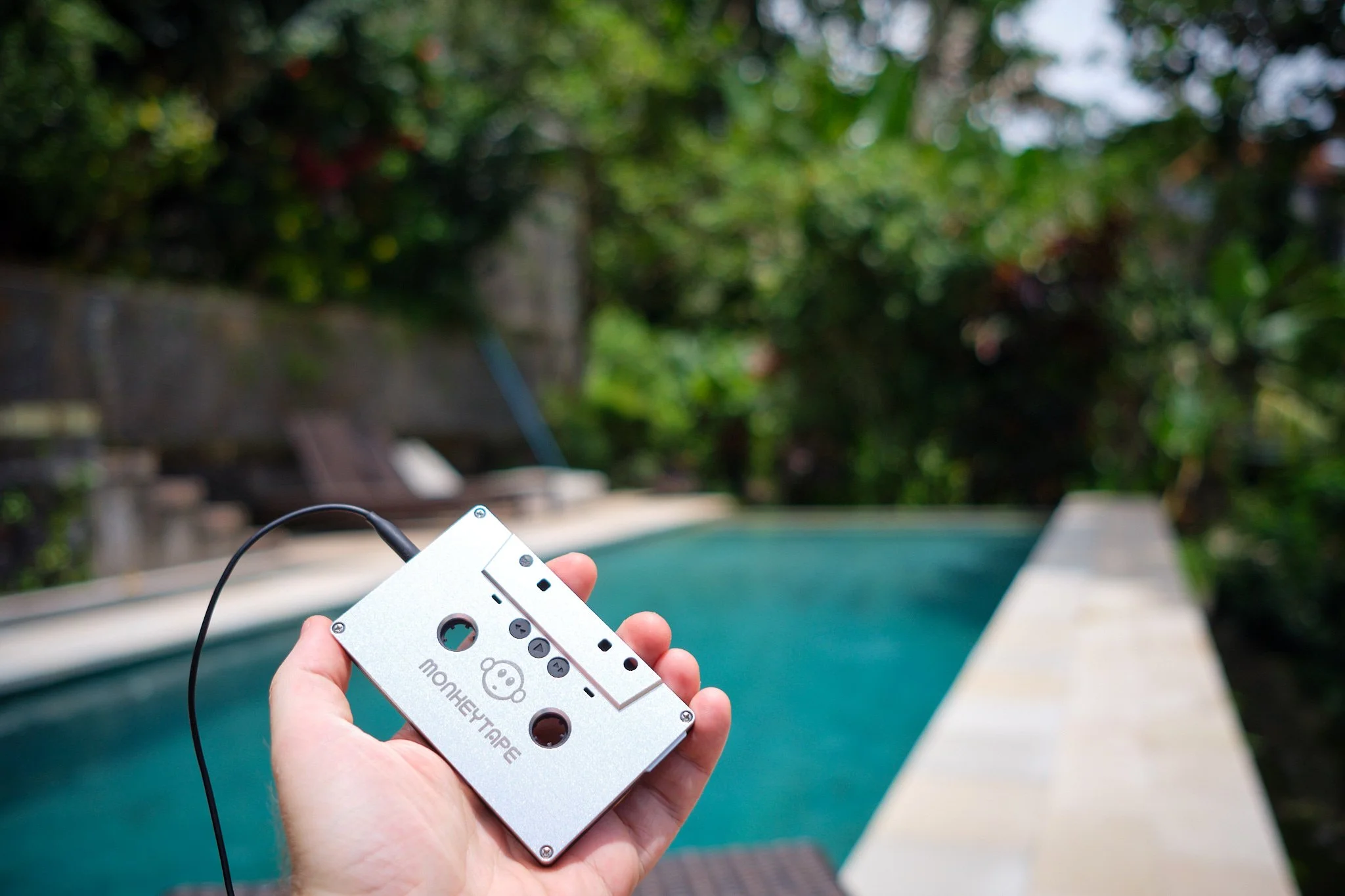 A vintage cassette tape with orange foam headphones resting on a wooden surface.