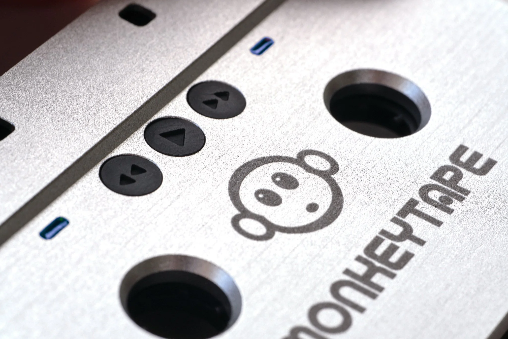 Close-up of a mixer with control buttons, a power switch, and a playful panda face logo, on a metallic surface.
