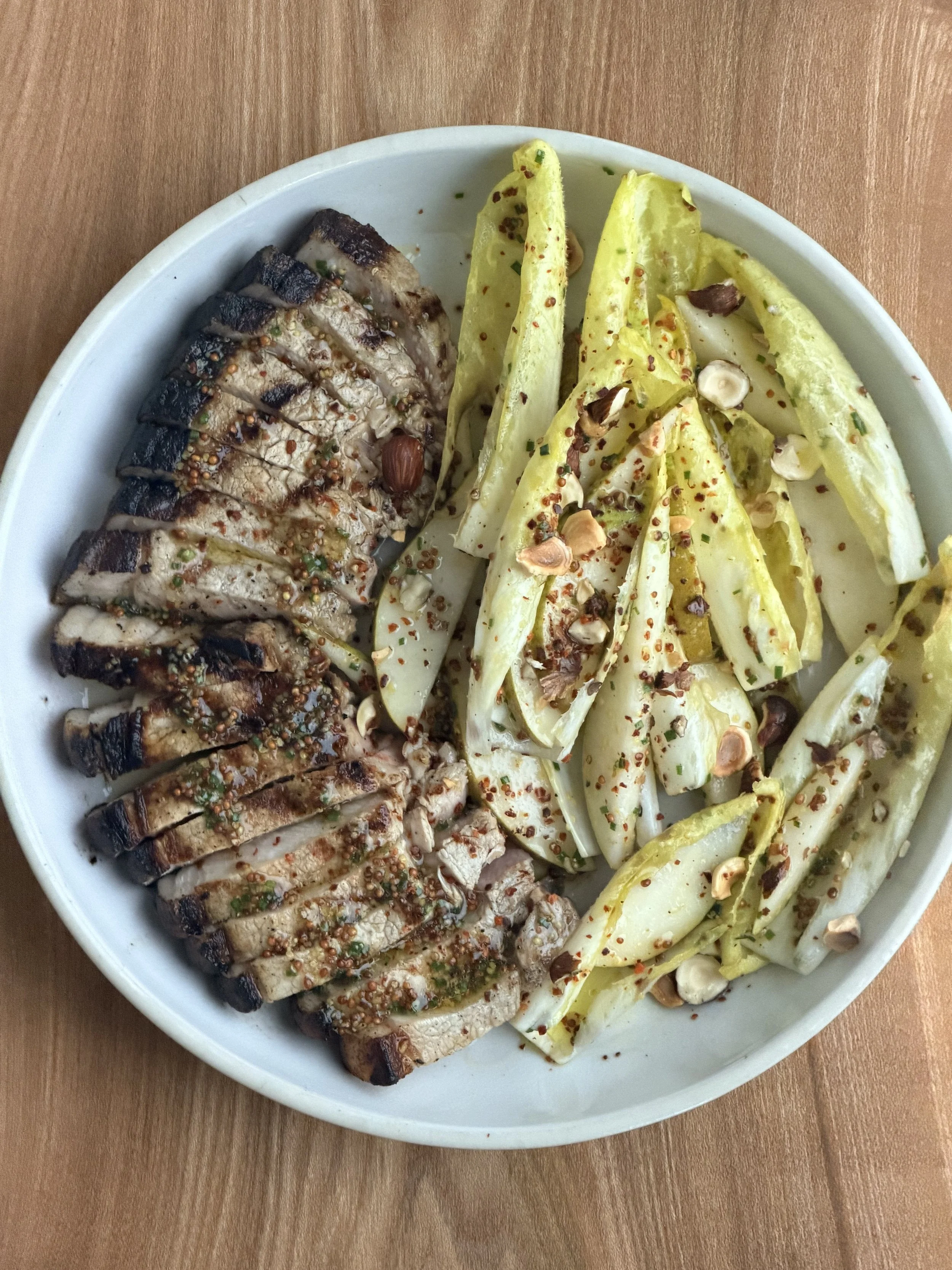 Pork Chop with pear, Chicory, Hazelnuts, Smoked Pineapple Vinegar Butter Dressing