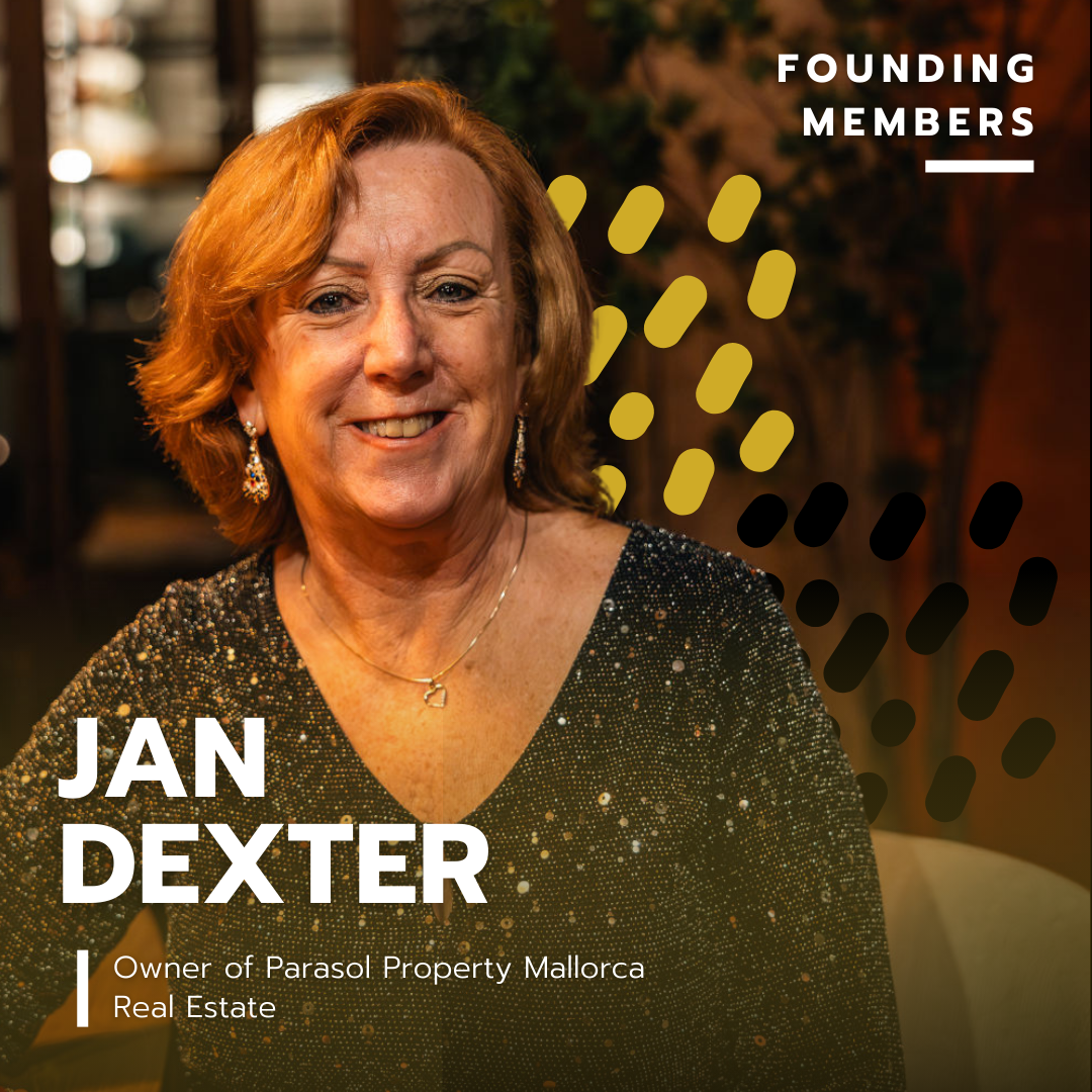 Portrait of Jan Dexter, owner of Parasol Property Mallorca, smiling, wearing earrings and a black sparkling top, in a dimly lit indoor setting with decorative elements in the background.