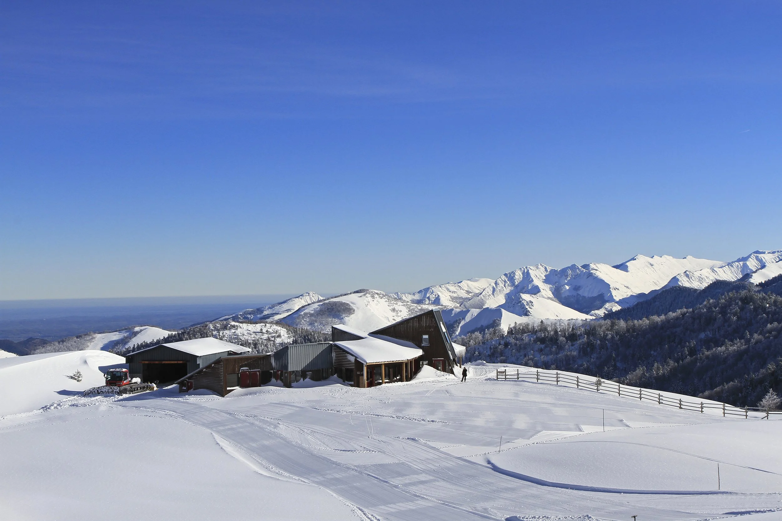 cabane en bois dans un paysage enneigé avec montagnes en arrière-plan
