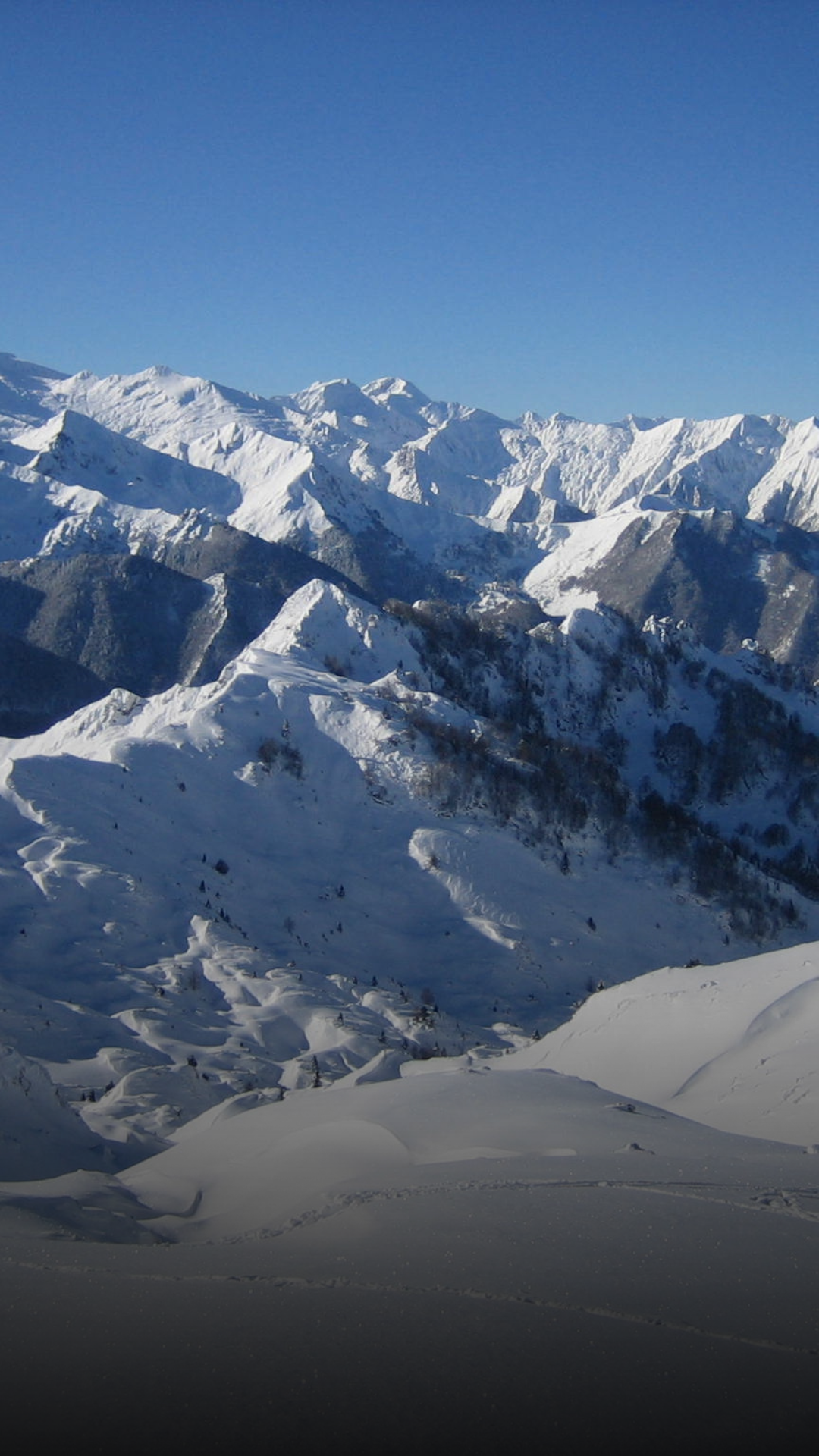 Montagnes enneigées avec ciel bleu clair.
