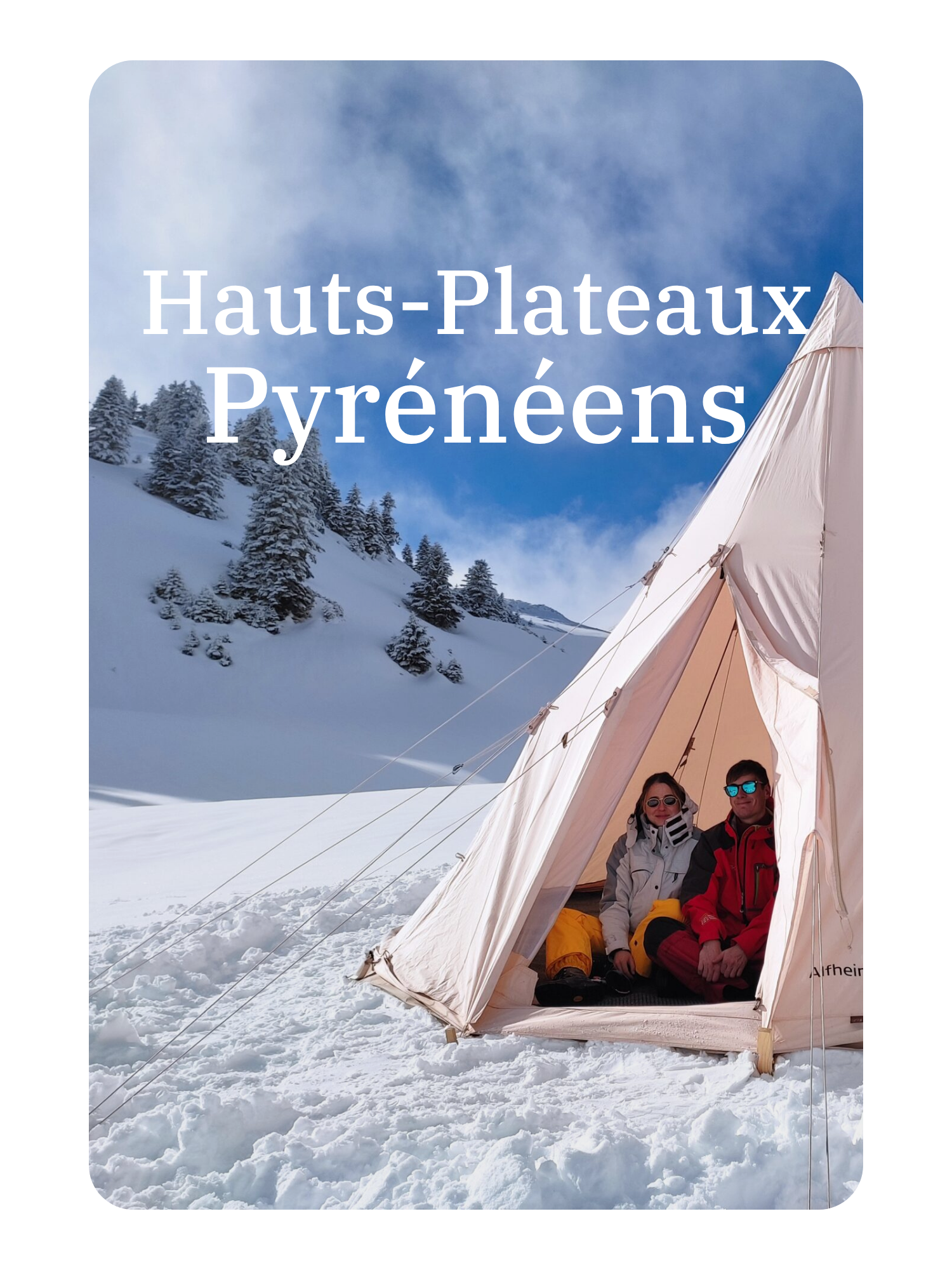 Deux personnes assises dans une tente dans un paysage enneigé avec des montagnes et des arbres, ciel bleu.