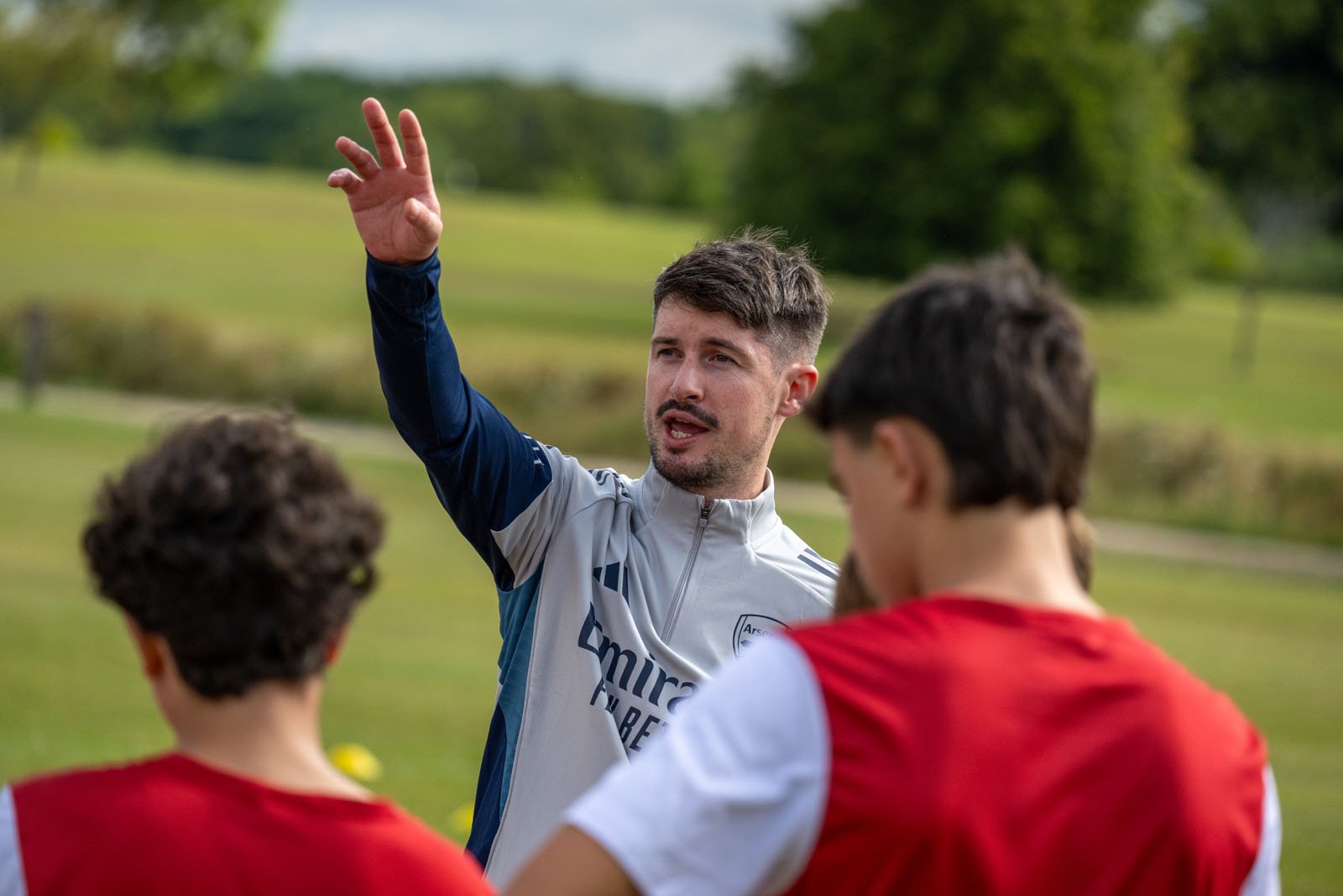 サッカーコーチが選手たちに戦術を説明している場面