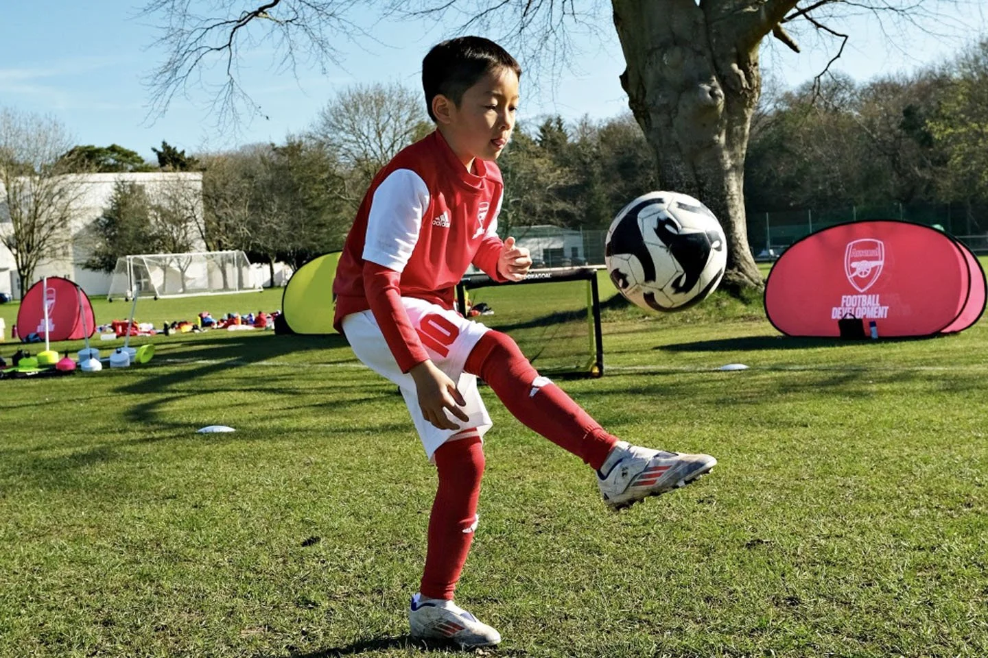 少年がサッカーボールを足で蹴っている