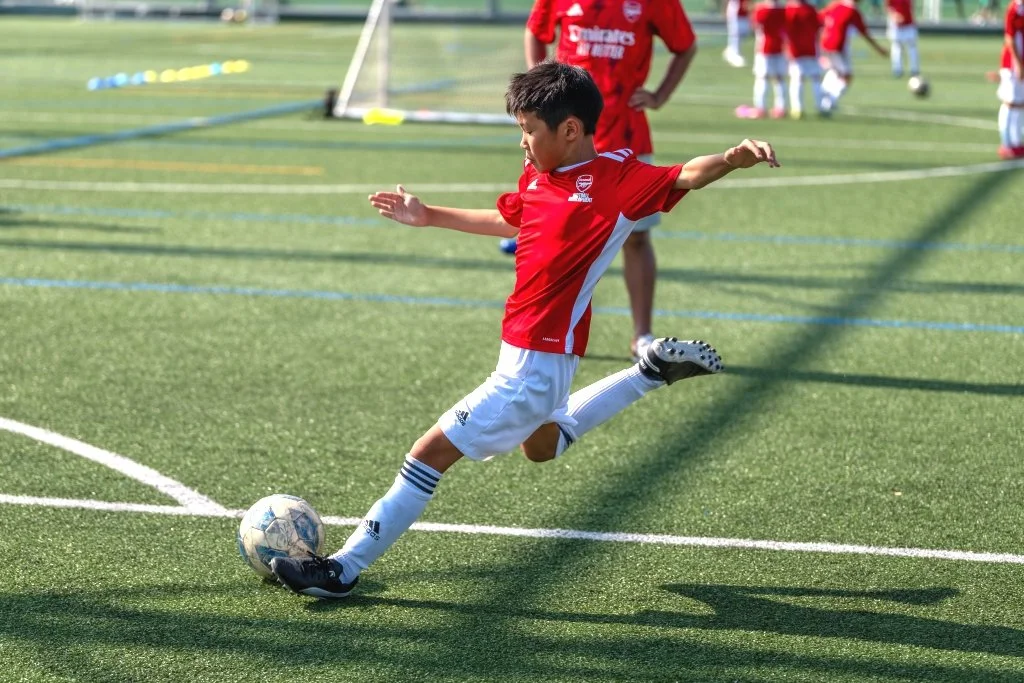 少年がサッカーの試合中にボールを蹴っている様子