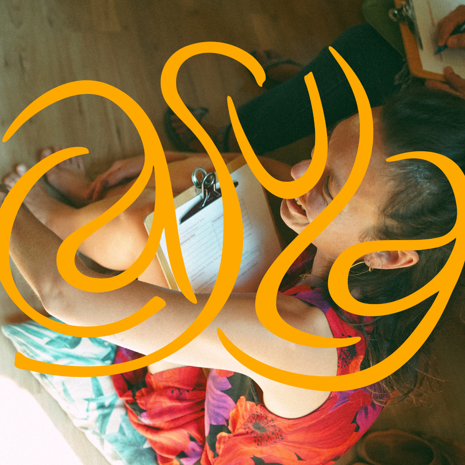 A woman laughing while lying on the floor, holding a clipboard and writing, with large orange numbers "2023" overlaid.