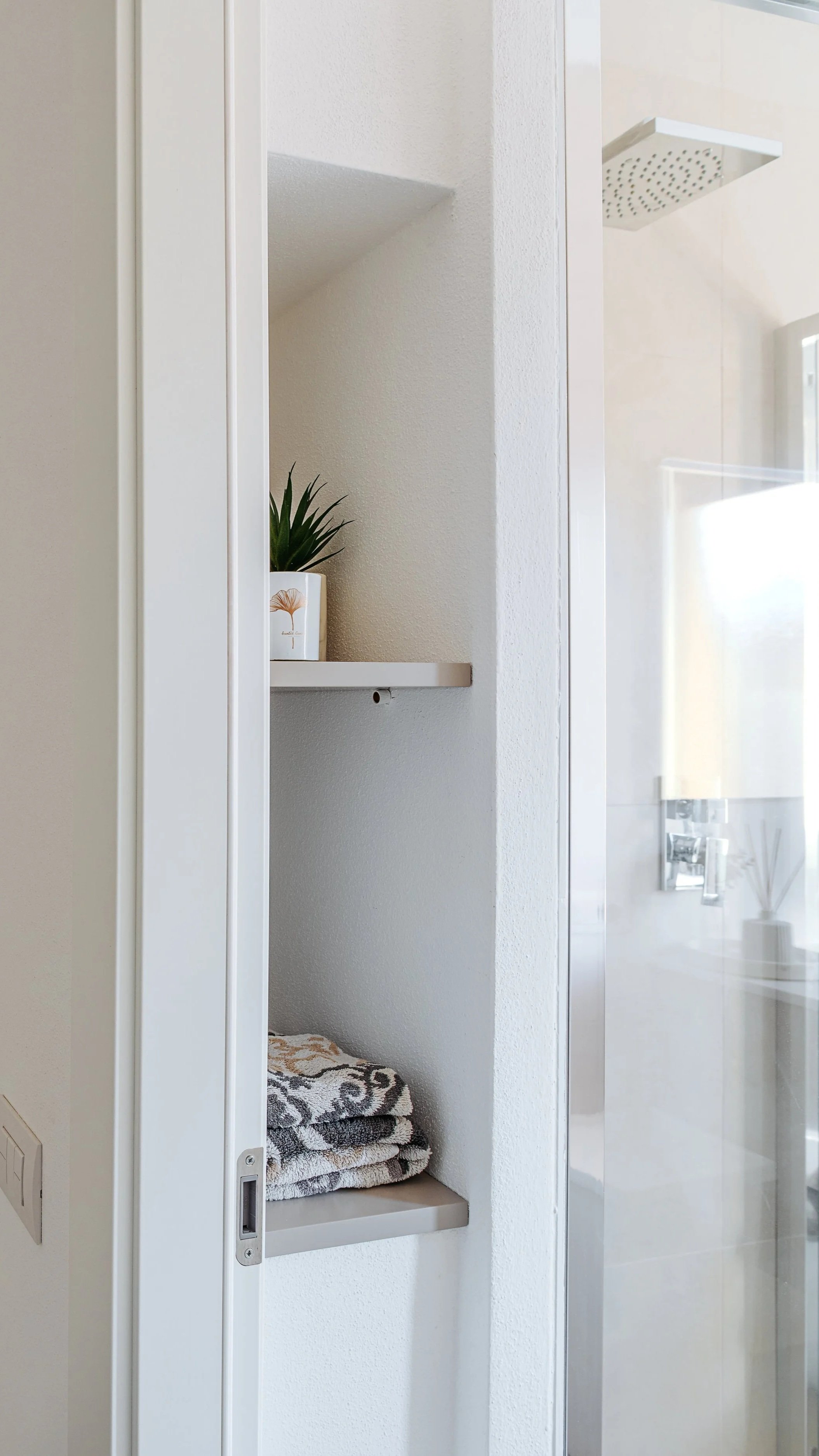 Dettaglio scaffali del ripostiglio con asciugamani piegati.