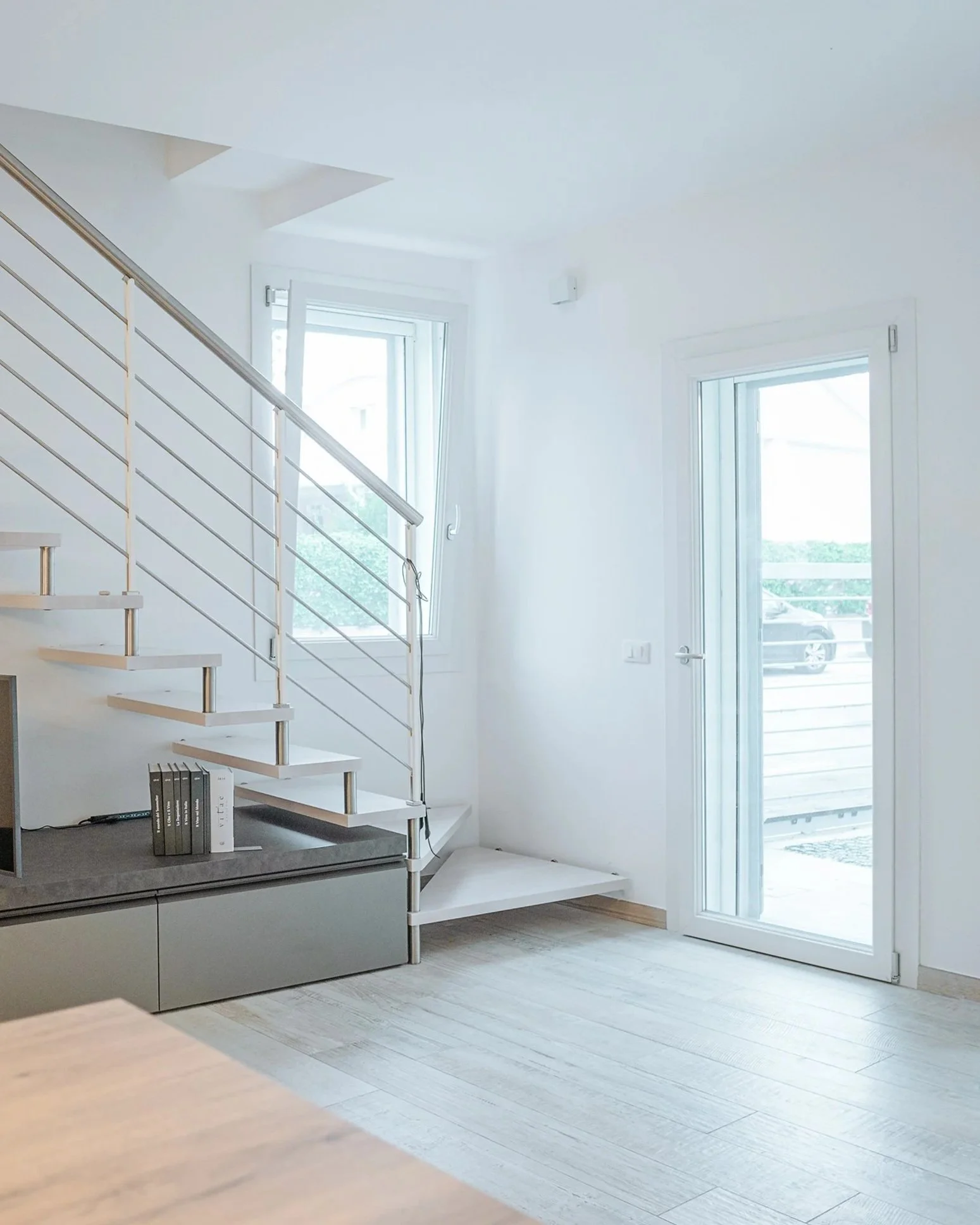 Soggiorno con scala e ampie aperture.
