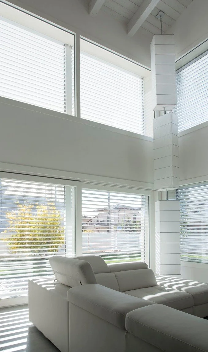 Zona giorno luminosa con grandi vetrate, progetto Casa per Elisa.