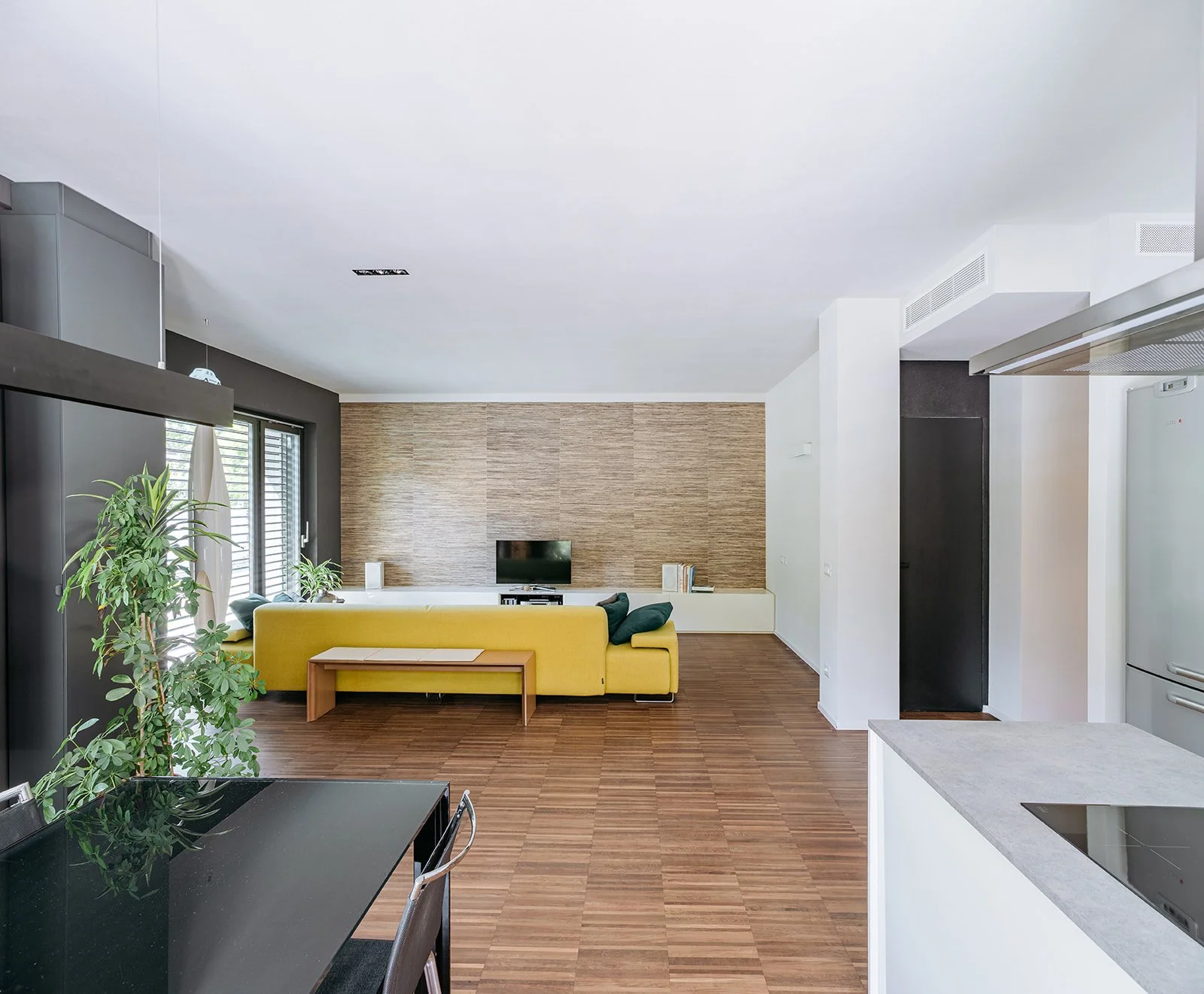 Vista prospettica del corridoio e della cucina di Casa a Savignano. Spazi fluidi, luce naturale e materiali caldi in un progetto firmato DAT Architetti.