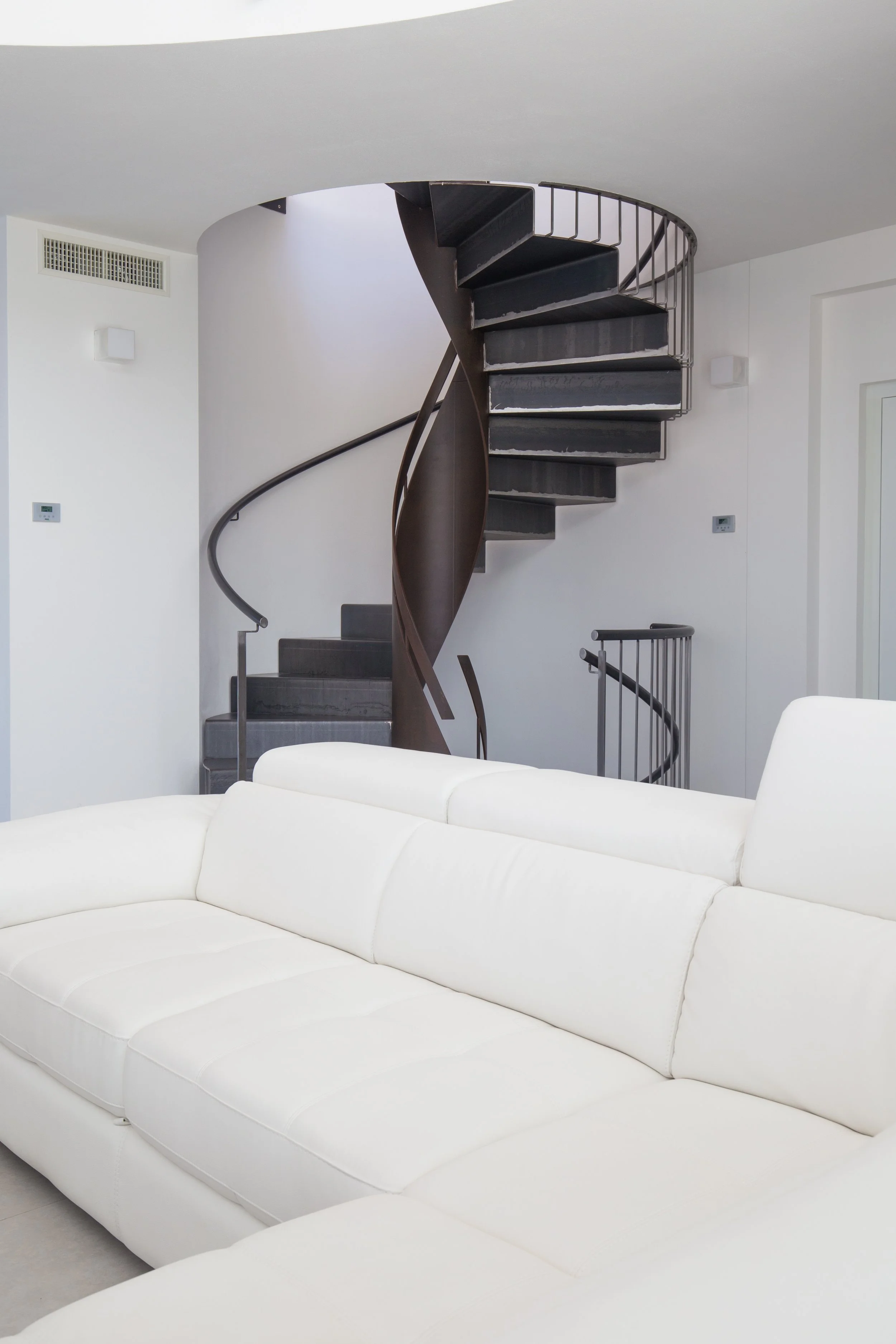 Vista della zona giorno di Casa per Elisa con scala elicoidale.