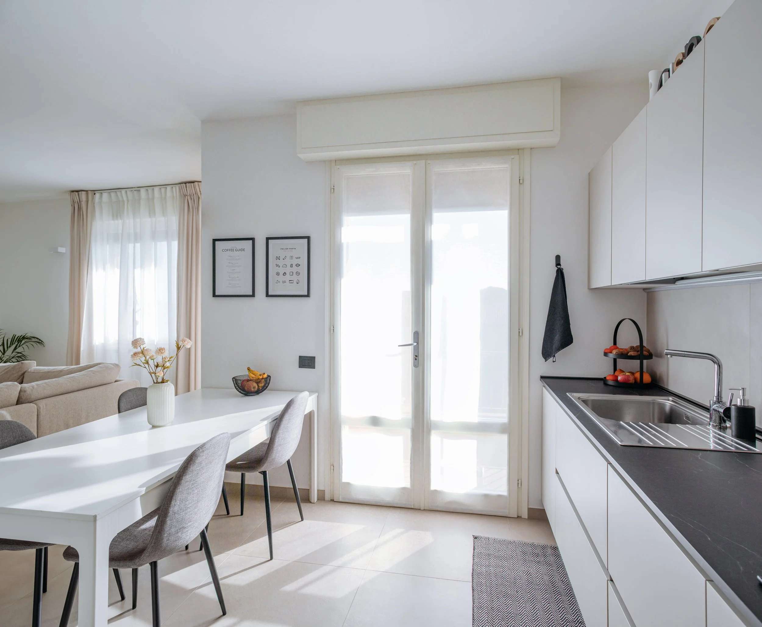 Cucina open space con tavolo da pranzo e luce naturale.