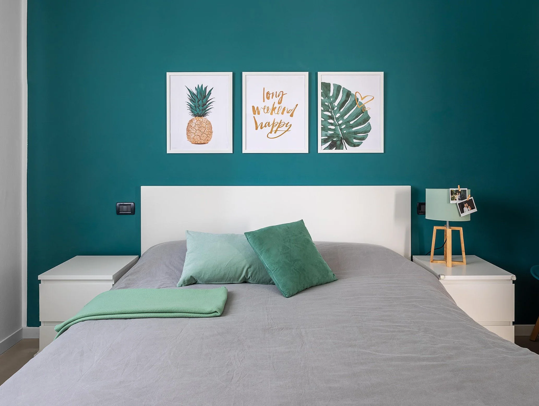 Camera matrimoniale con parete color petrolio e complementi verde menta, progetto di interni di DAT Architetti.