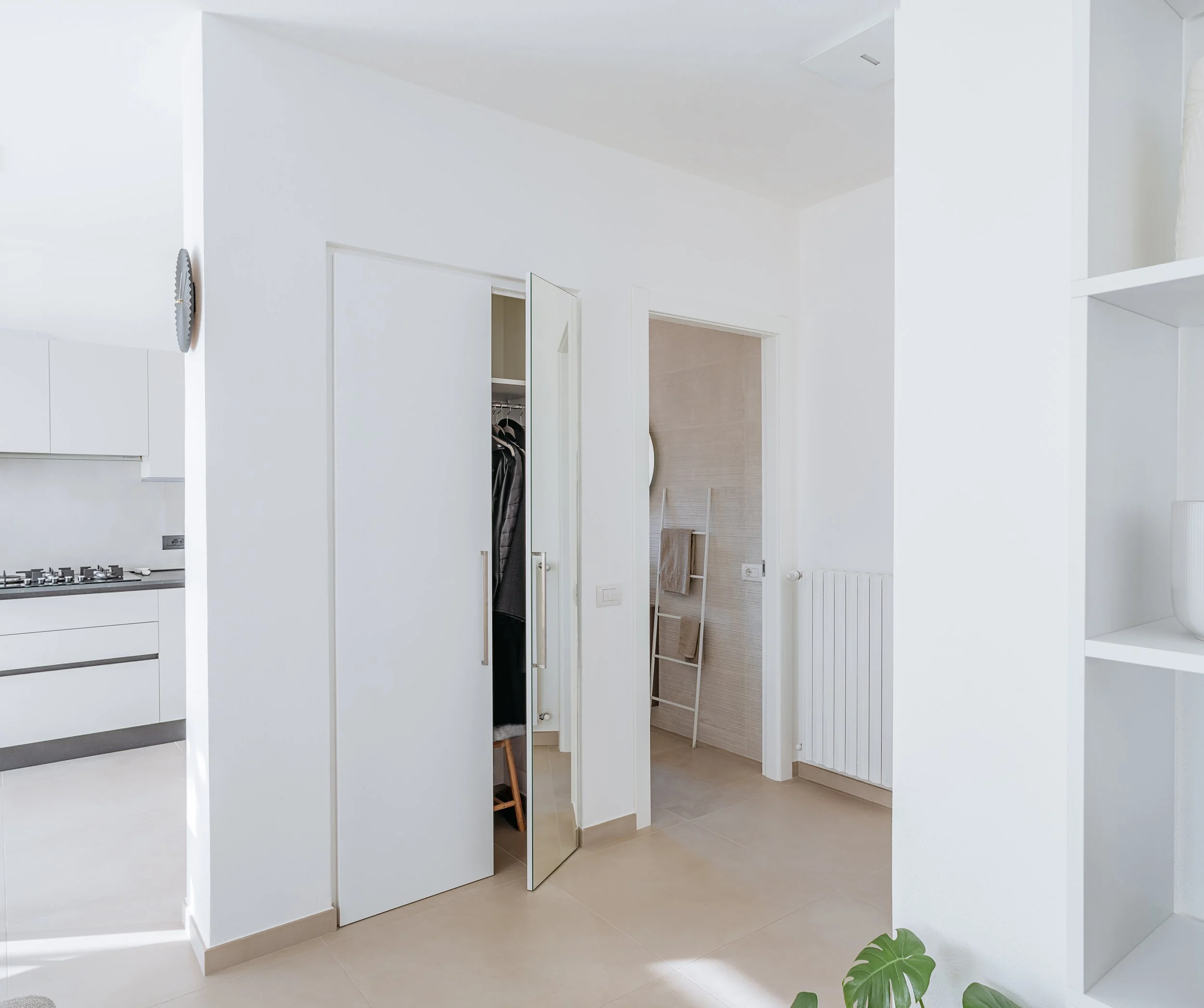 Ingresso dell’appartamento luminoso con armadio a muro e pavimento chiaro.