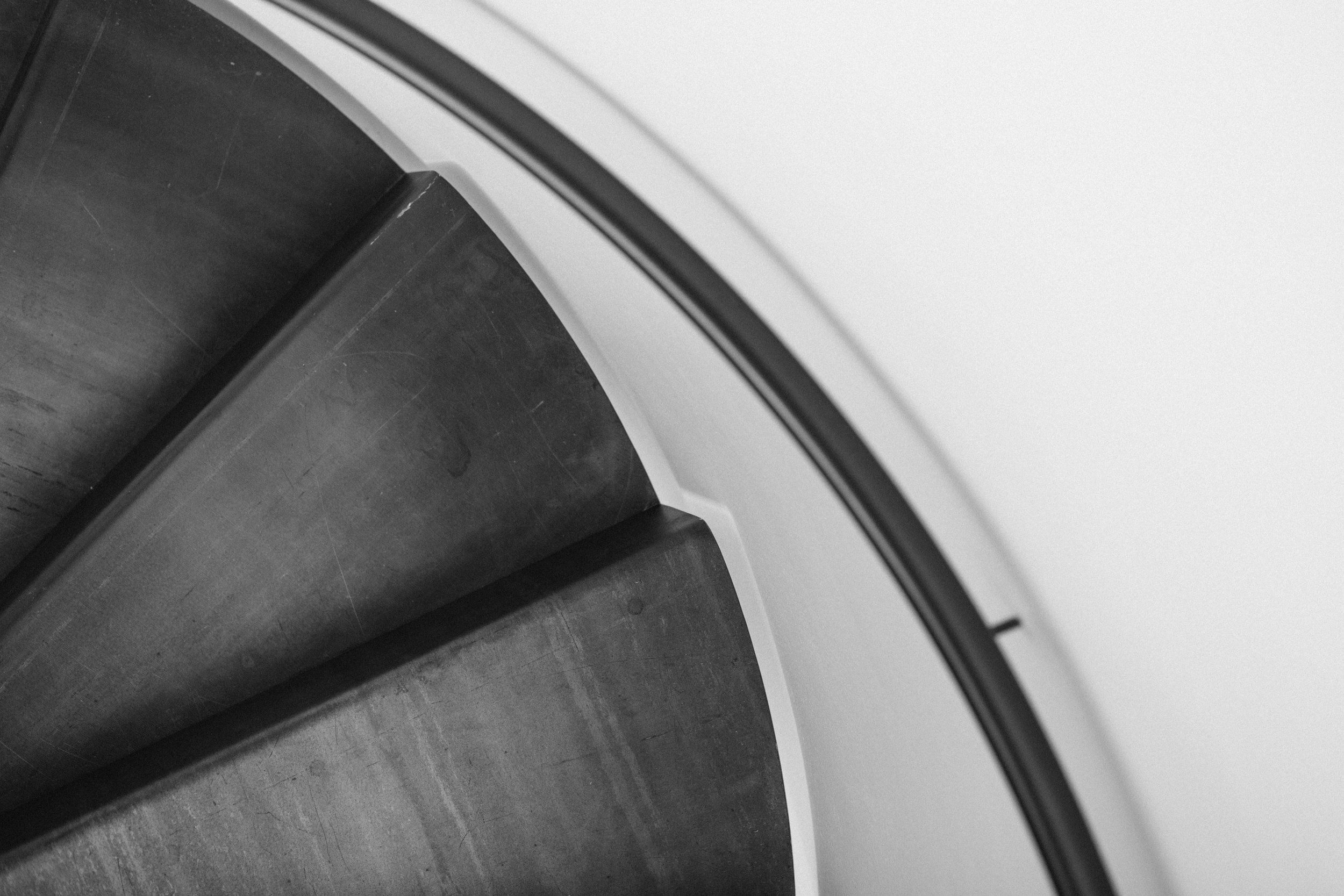 Dettaglio della scala in ferro con gradini in lamiera piegata, progettata su misura per Casa per Elisa.