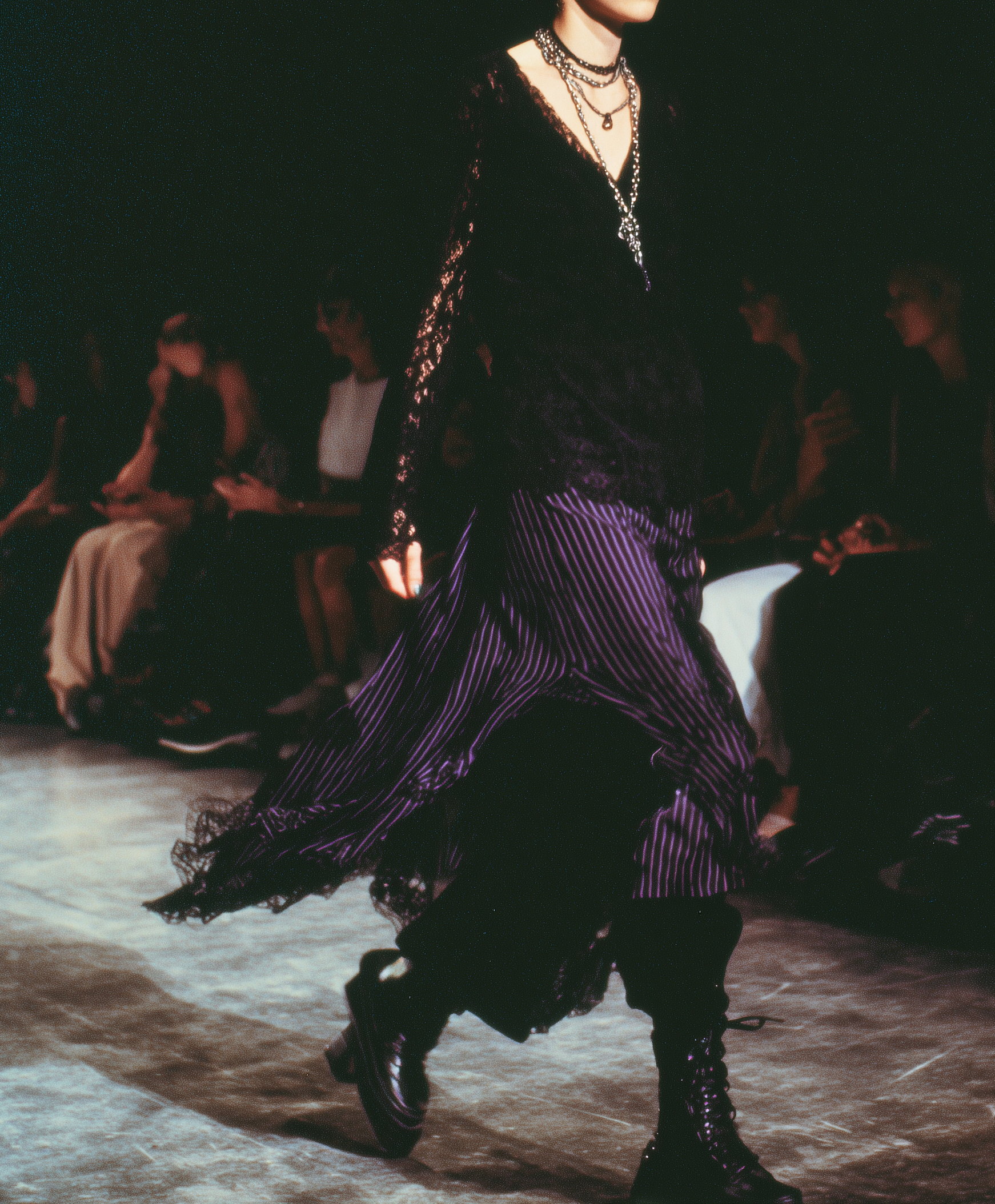 Laufstegfoto eines Models in einem schwarz-lila Outfit