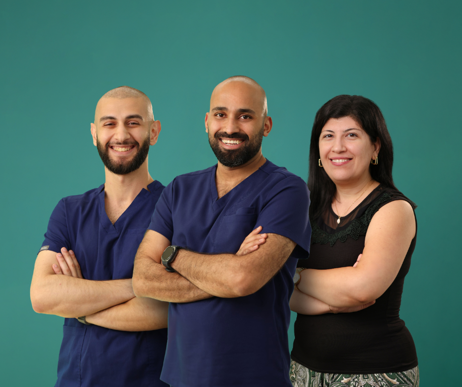 Three healthcare professionals, two men and one woman, posing with crossed arms and smiling against a plain green background.