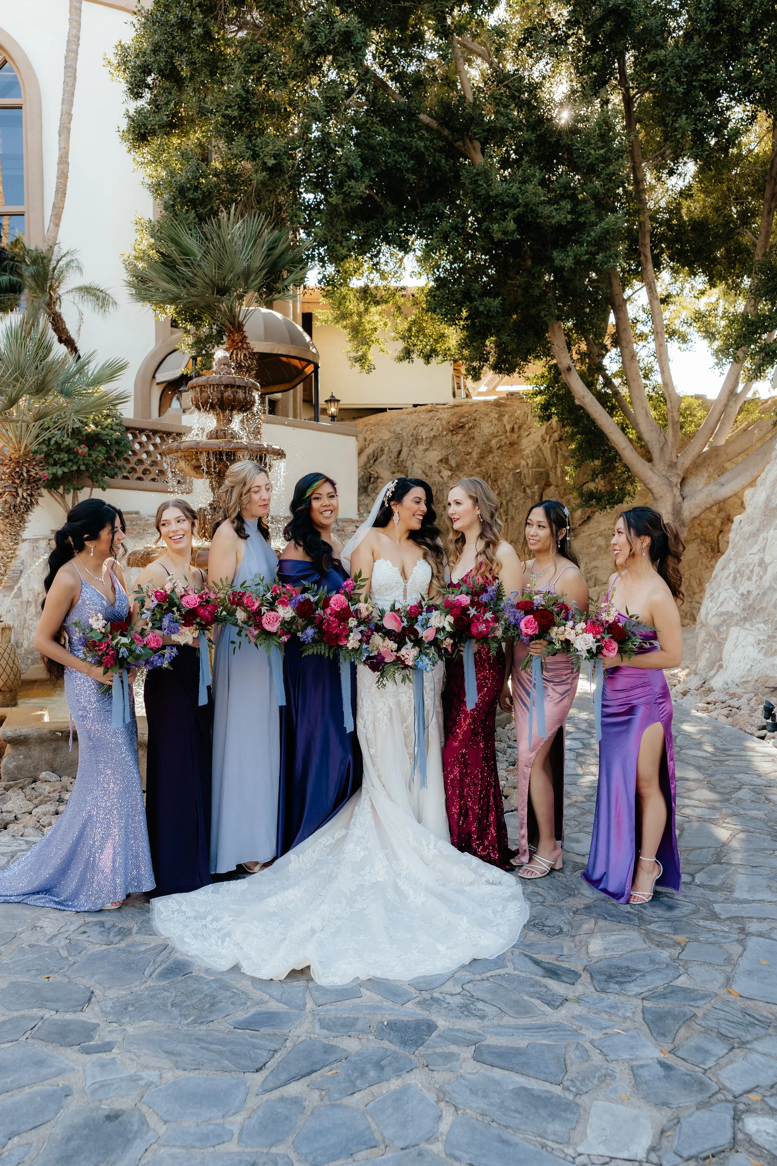 Bride and bridesmaids holding loose garden-style wedding bouquets filled with white flowers and greenery.