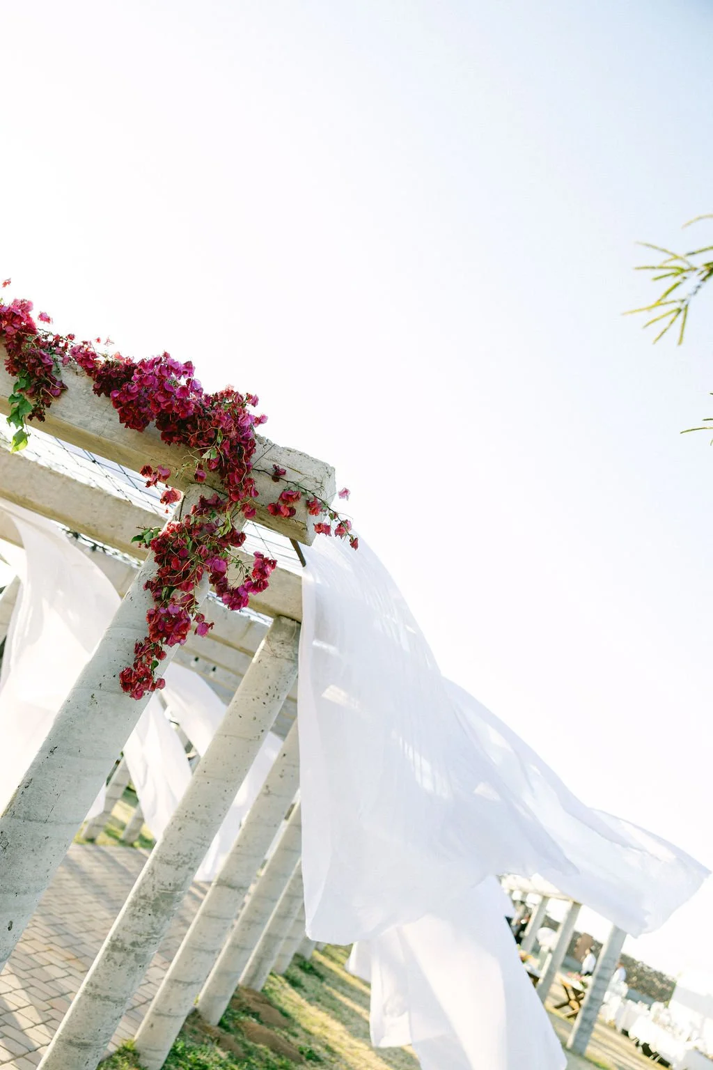 Eclectic backyard wedding table decorated with colorful flowers, bud vases and pillar candles.