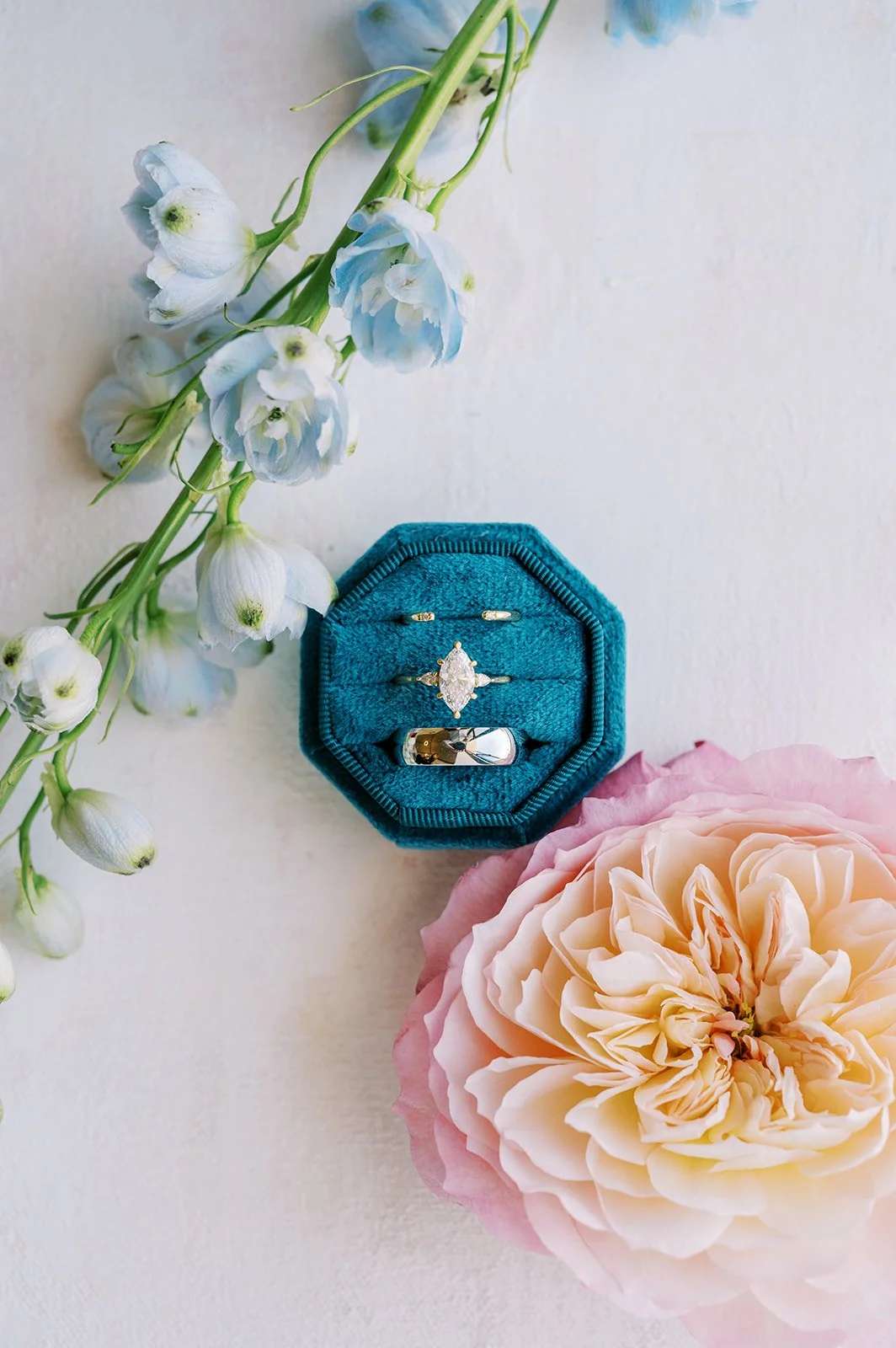 Colorful wedding detail flat lay with blue accents, soft flowers and romantic bridal details.