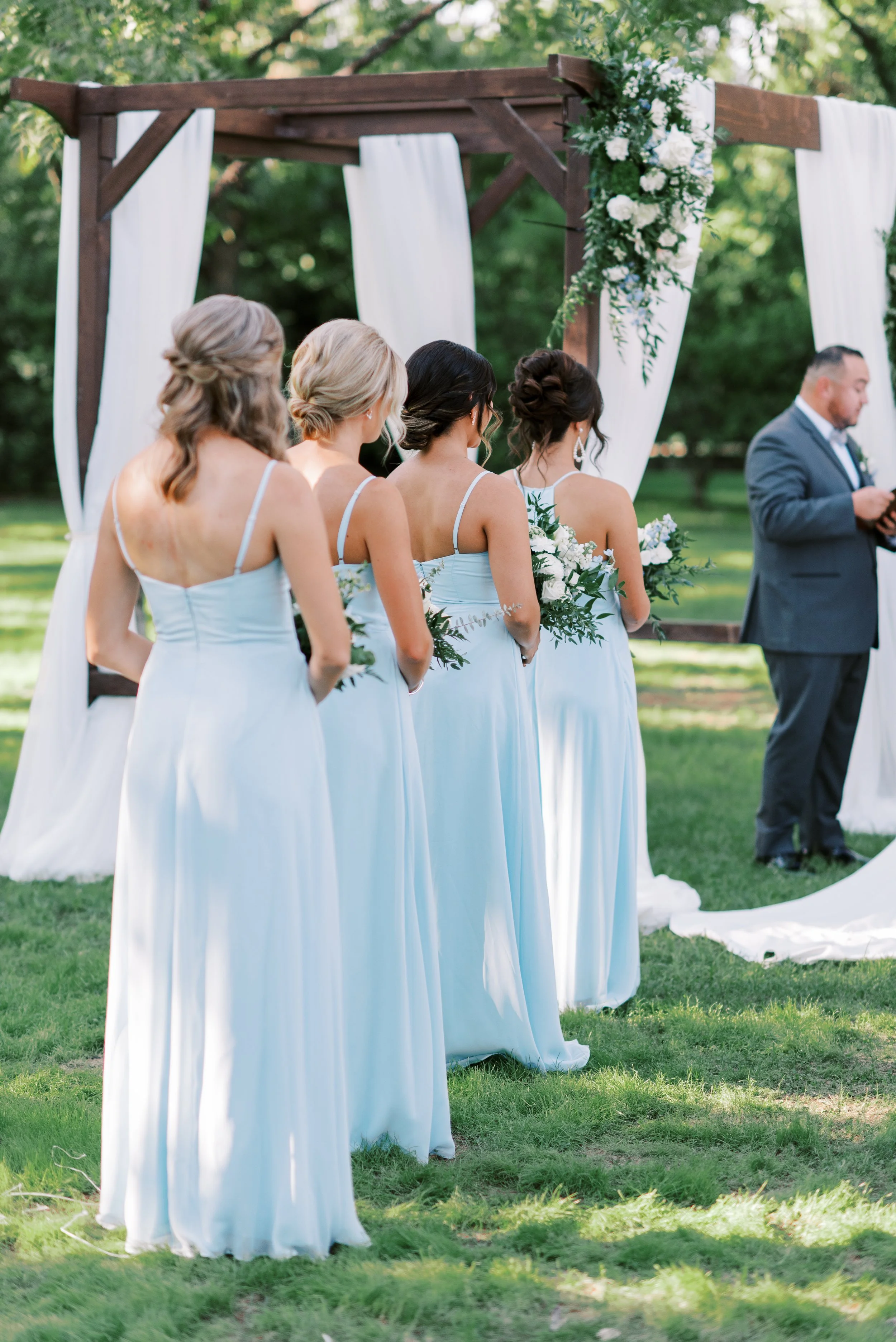 Bridesmaids in soft blue dresses during an elegant Venue at the Grove wedding ceremony.