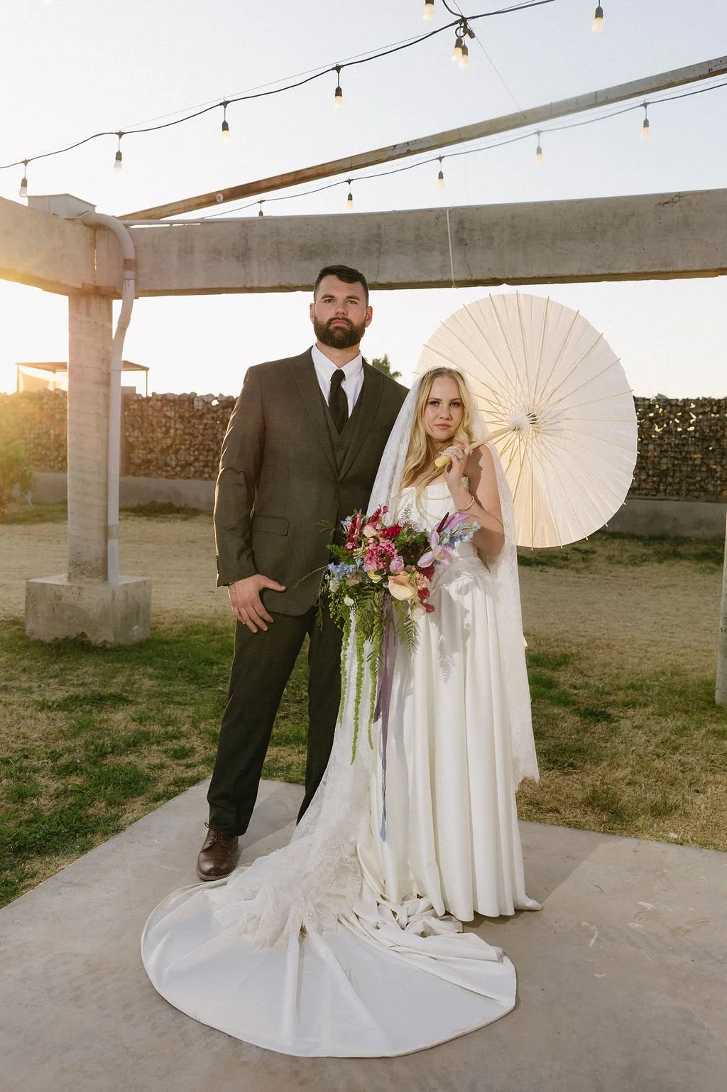 Bride and groom portrait at an intimate backyard wedding with colorful garden-inspired flowers.