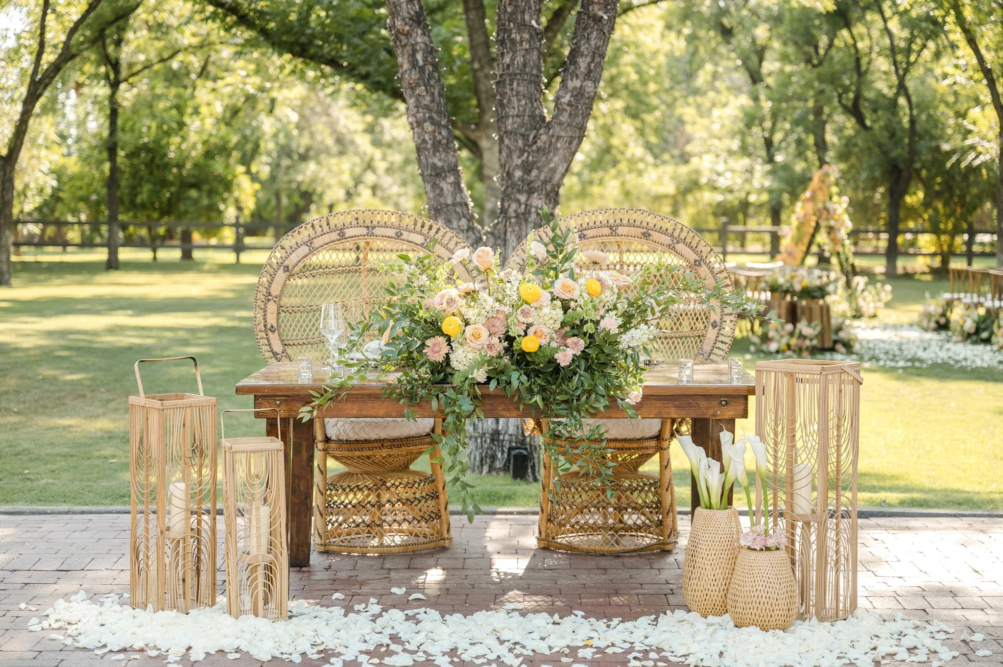 Garden-style wedding flowers arranged around rustic wooden ceremony décor beneath the trees at Venue at the Grove.
