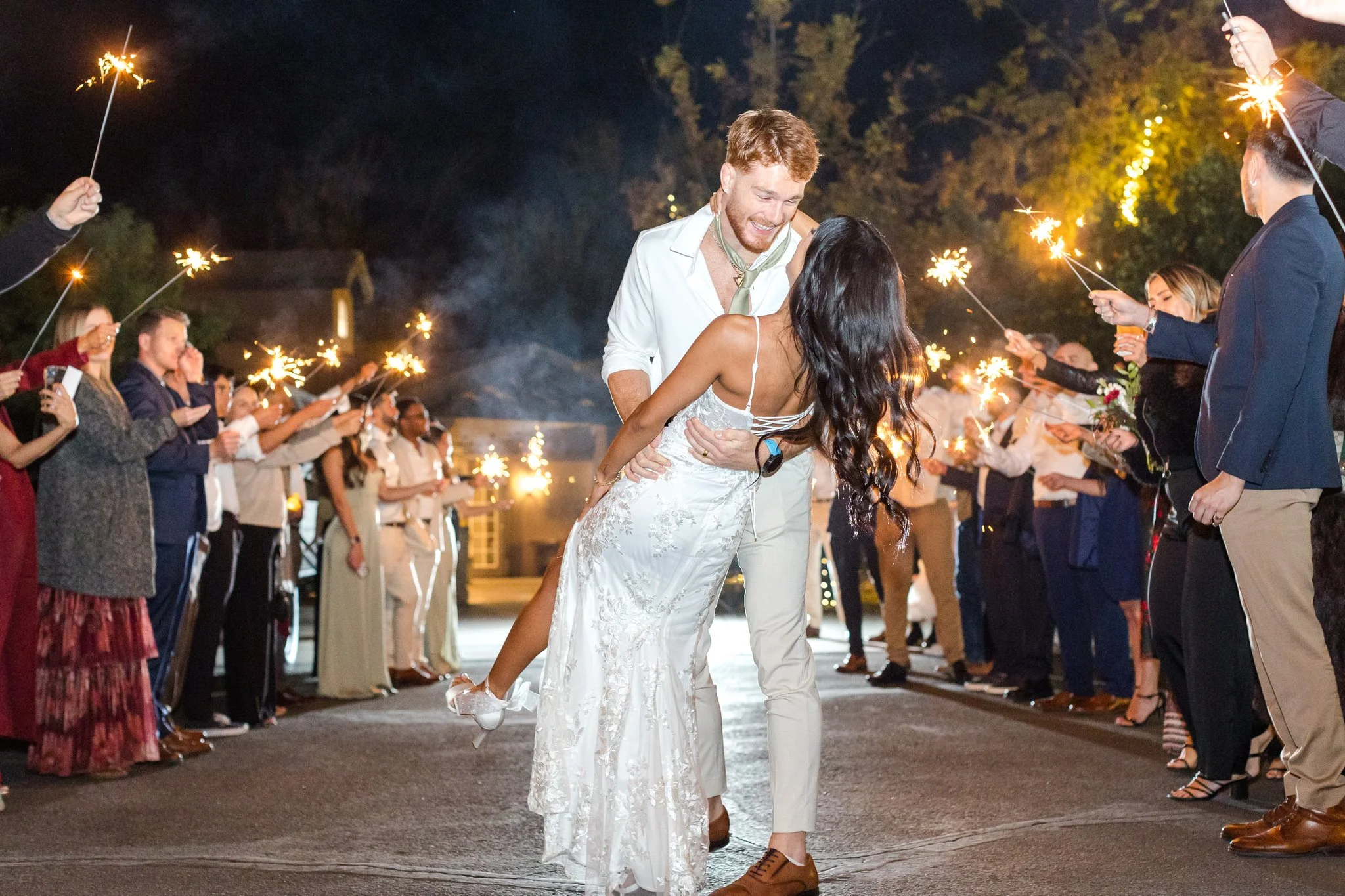 Newlyweds celebrating beneath sparklers at the end of their romantic Arizona wedding.
