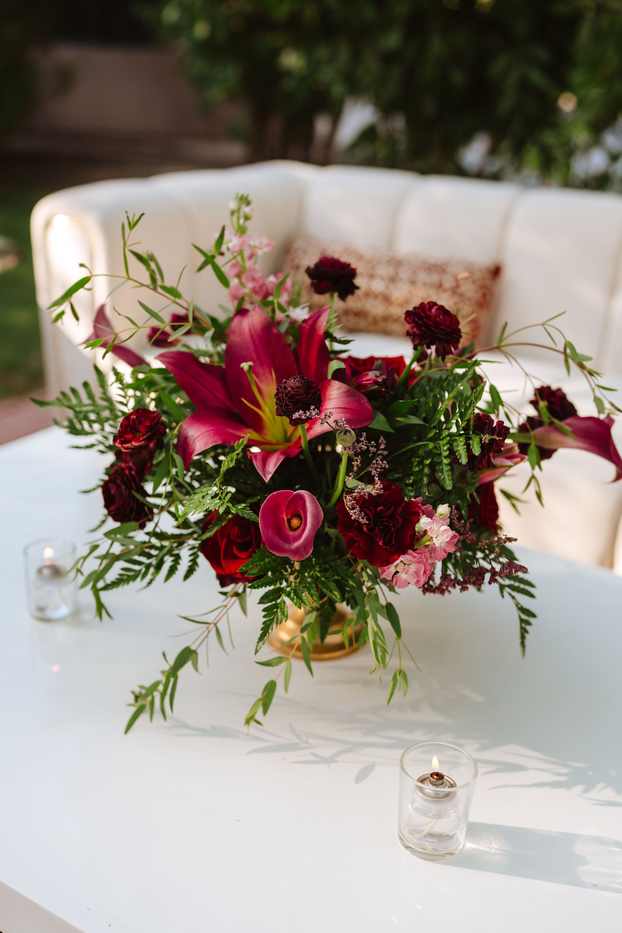Lush red and burgundy wedding floral arrangement with roses, lilies and organic greenery at Venue at the Grove.