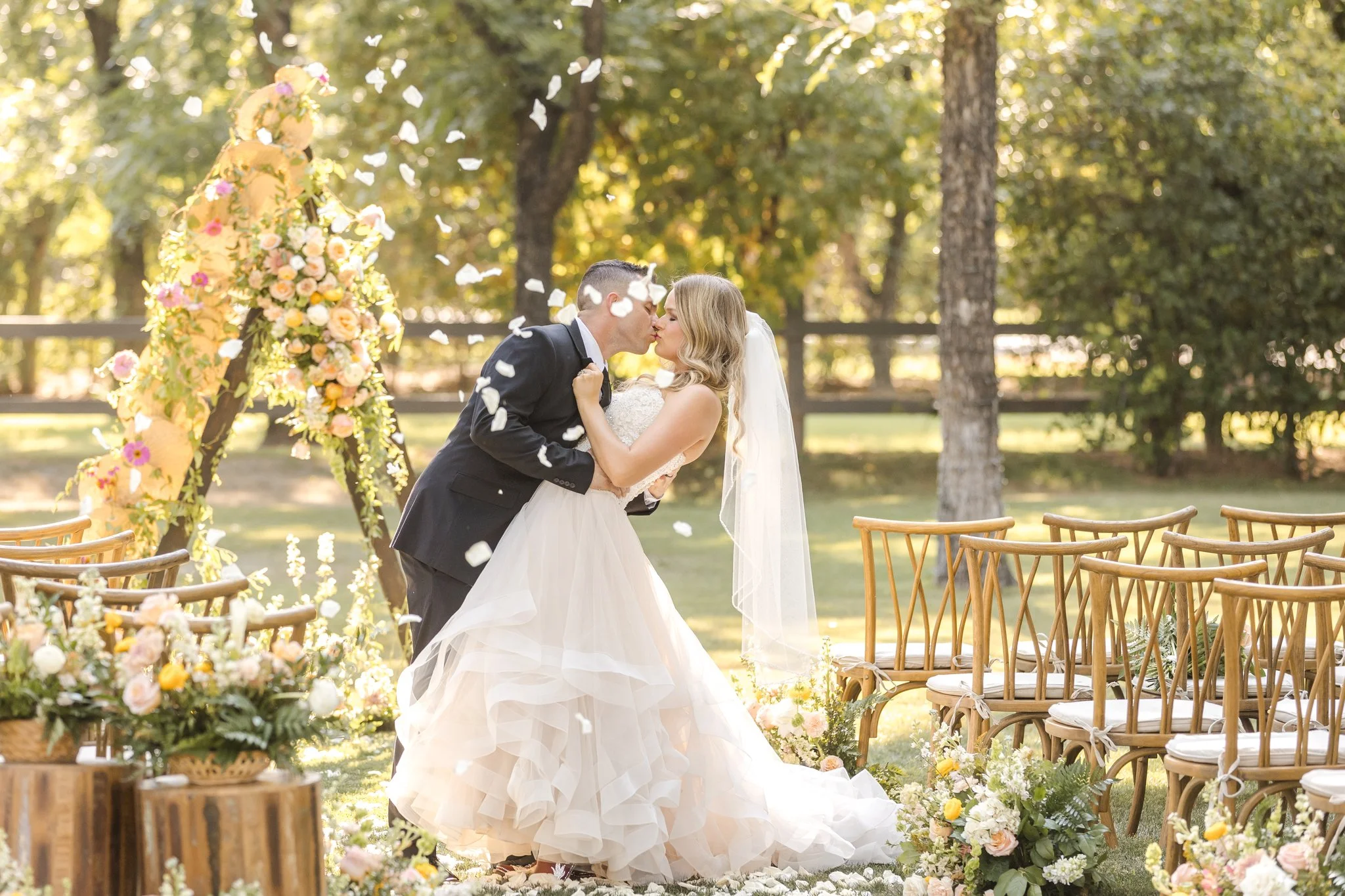 Bride in a white wedding gown beside colorful garden-inspired ceremony flowers at Venue at the Grove.