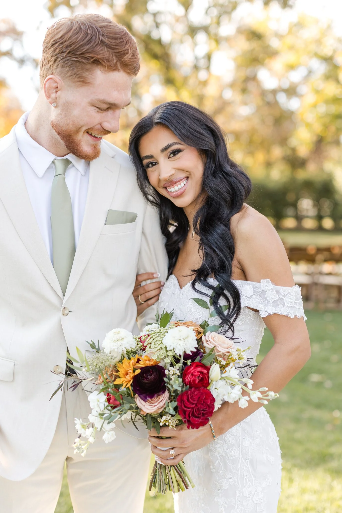 Bride and groom portrait with a colorful fall bridal bouquet featuring burgundy, peach and cream flowers.