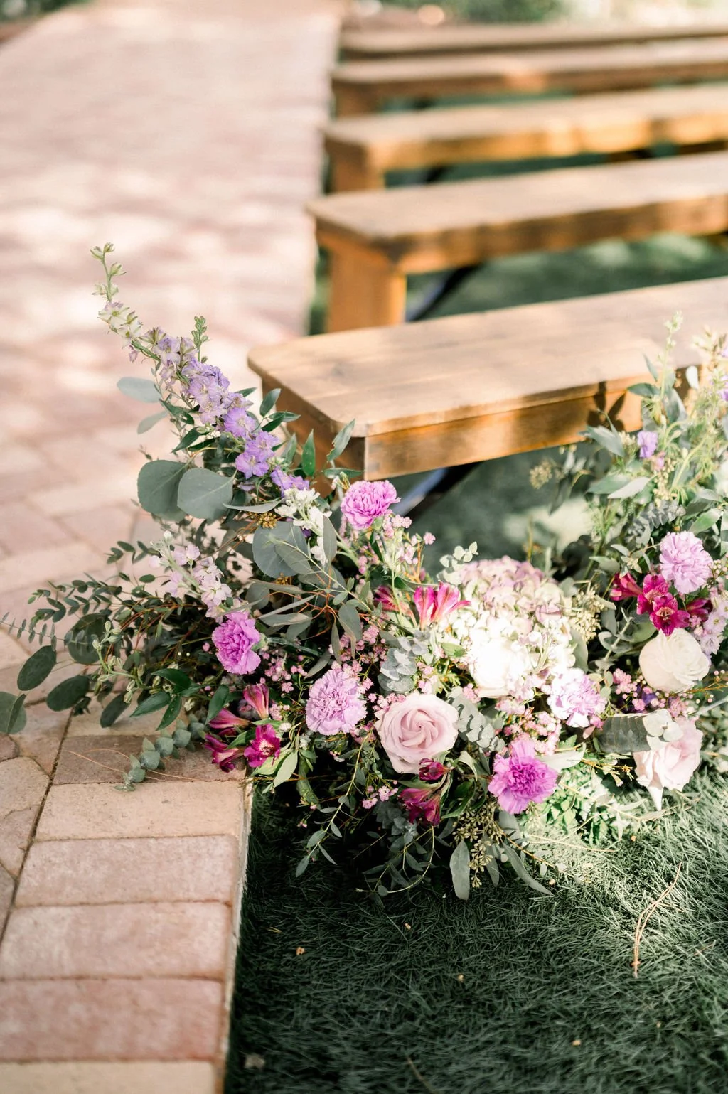 Lush garden-inspired wedding arrangement featuring lavender, purple, blush pink and white flowers with organic greenery.