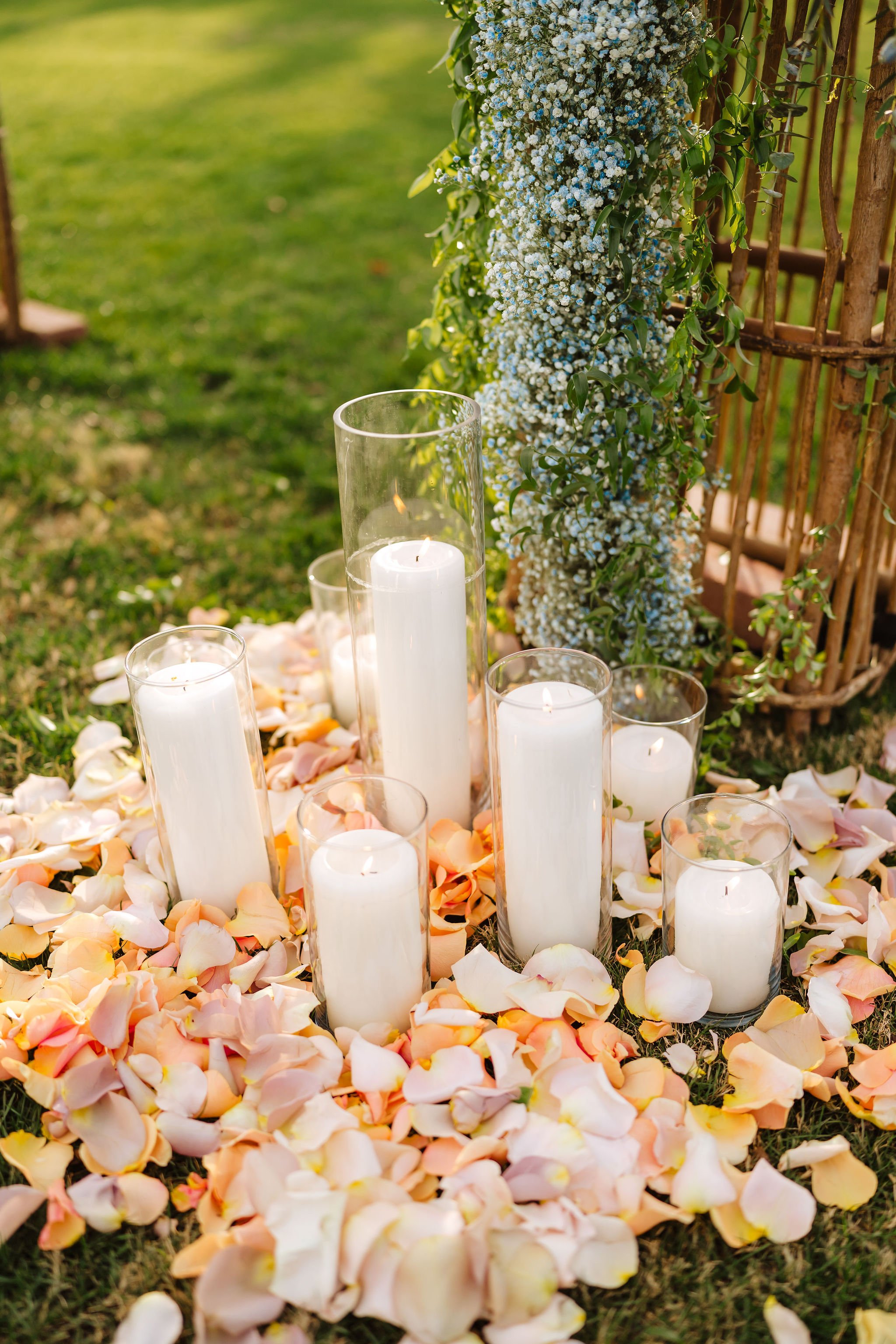 Romantic candle and floral wedding centerpiece with peach flowers and warm pillar candles.