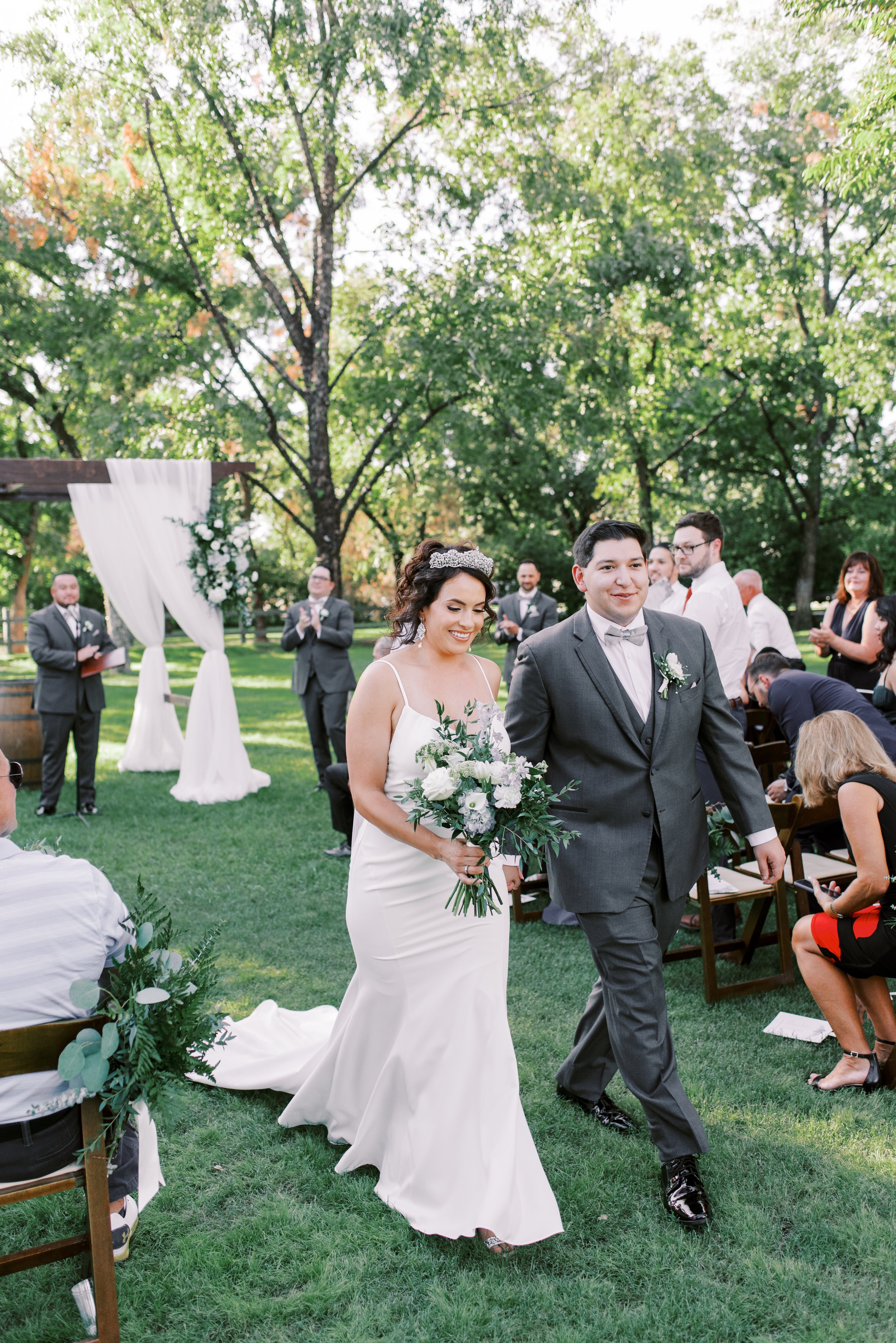 Bride and groom walking down the aisle after their outdoor garden wedding ceremony at Venue at the Grove.