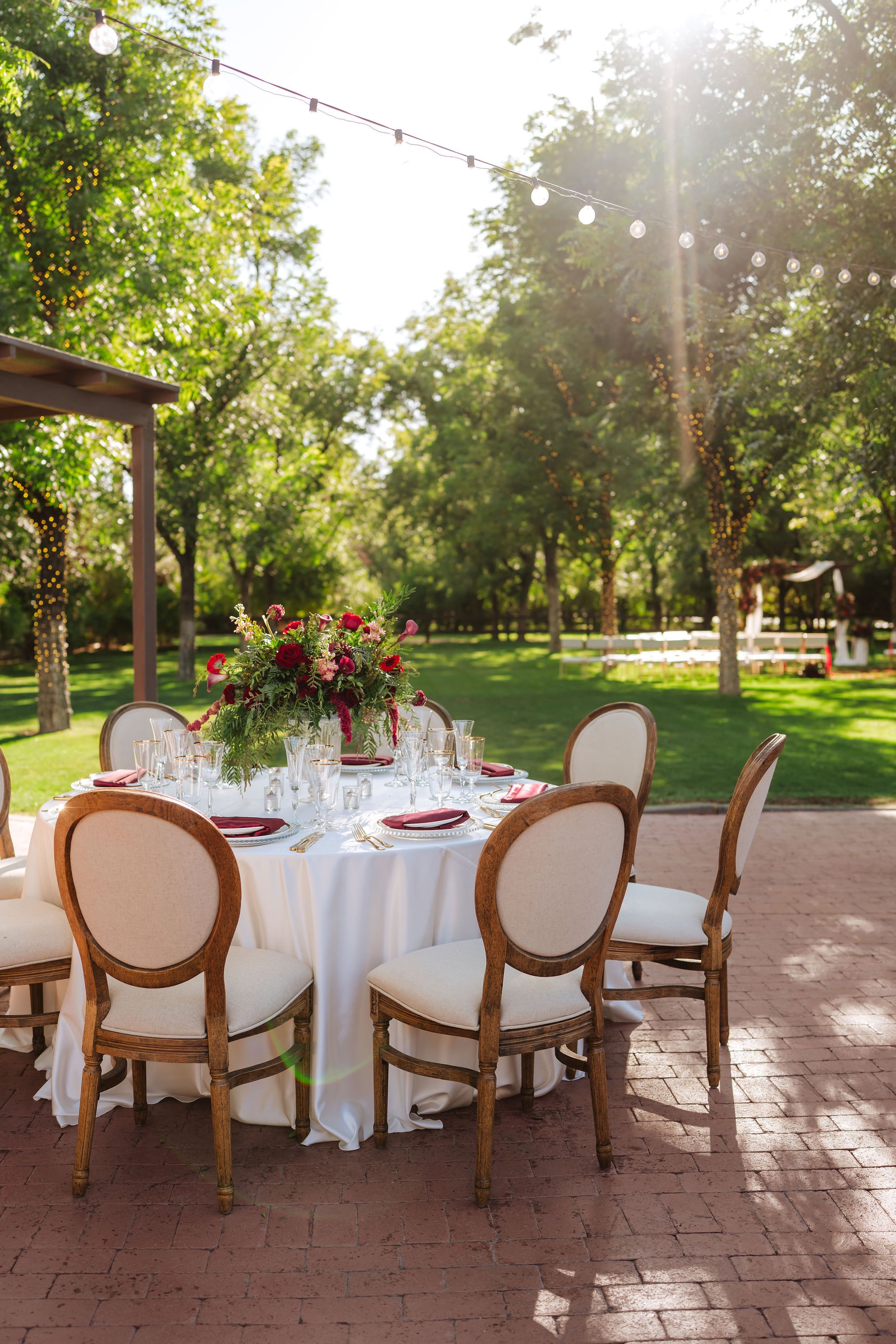 Outdoor Venue at the Grove wedding reception with elegant tables surrounded by mature trees and garden greenery.