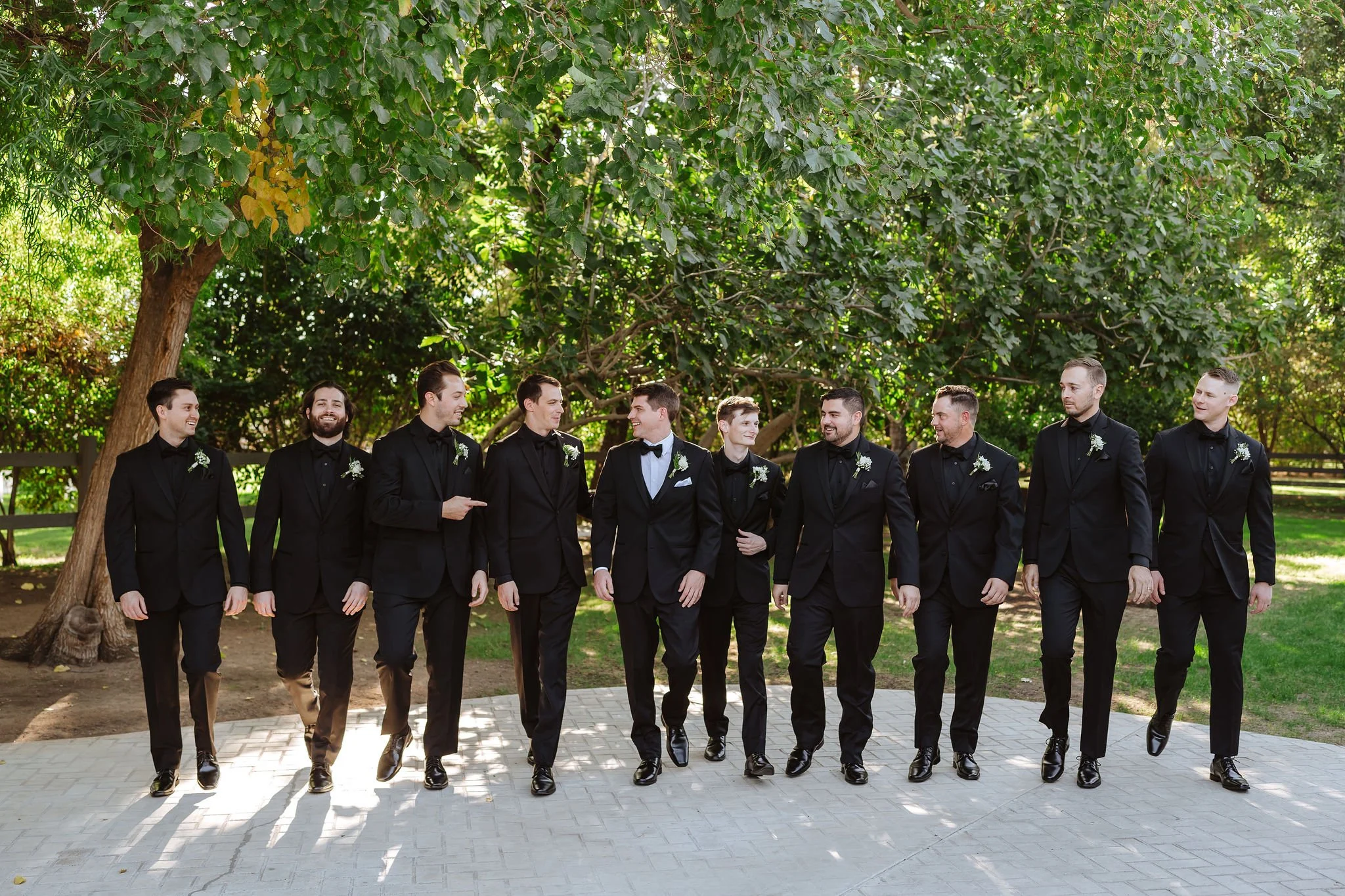 Groom and groomsmen in black suits at an elegant outdoor Arizona wedding.