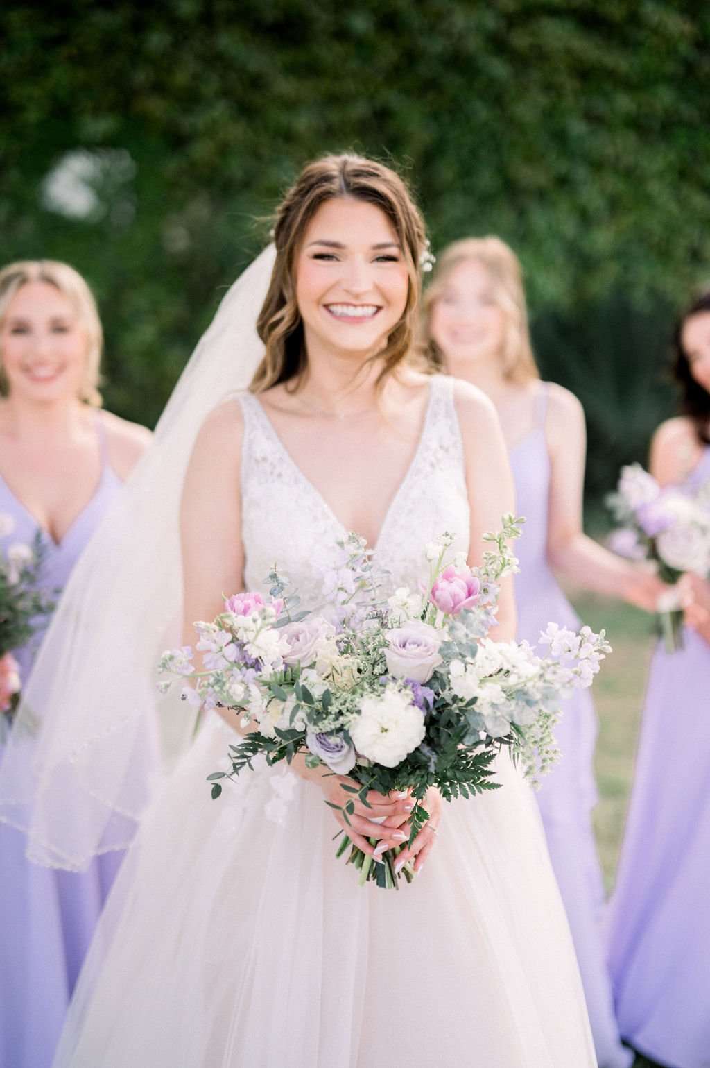 Bride holding a romantic lavender, blush and white garden-style wedding bouquet with soft greenery at Knotty Barn.