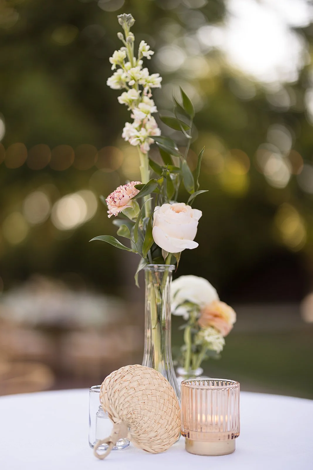 Delicate bud vase wedding centerpiece with soft pink and white flowers at an Arizona garden wedding.