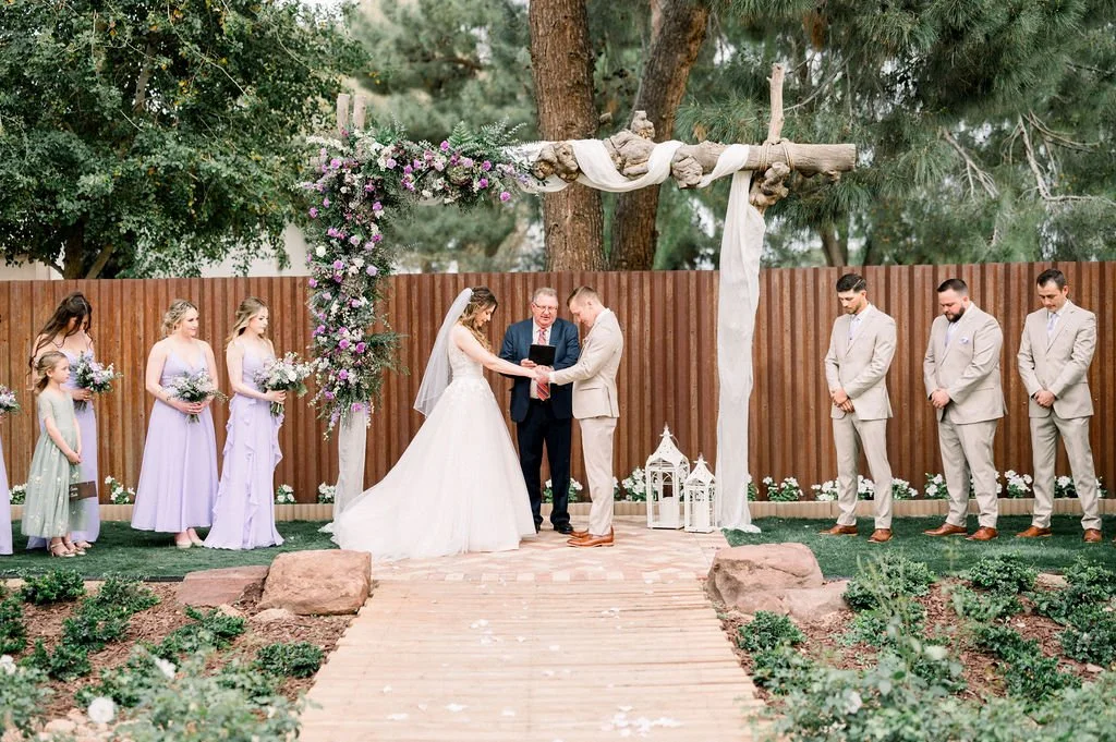 Outdoor wedding ceremony at Knotty Barn with romantic lavender, pink and white floral arrangements framing the ceremony space.