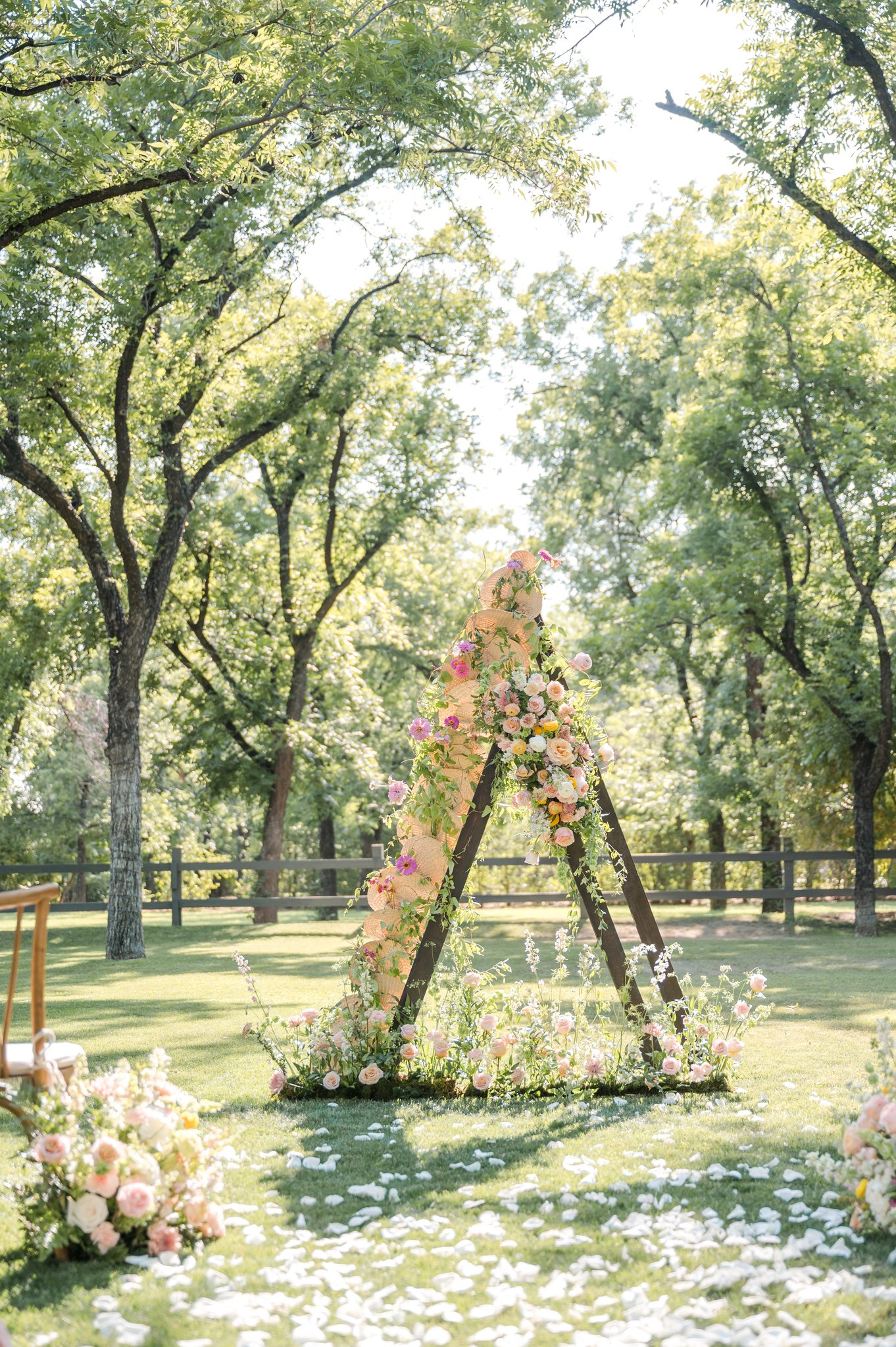 Colorful outdoor wedding ceremony surrounded by trees with organic floral installations at Venue at the Grove in Phoenix, Arizona.