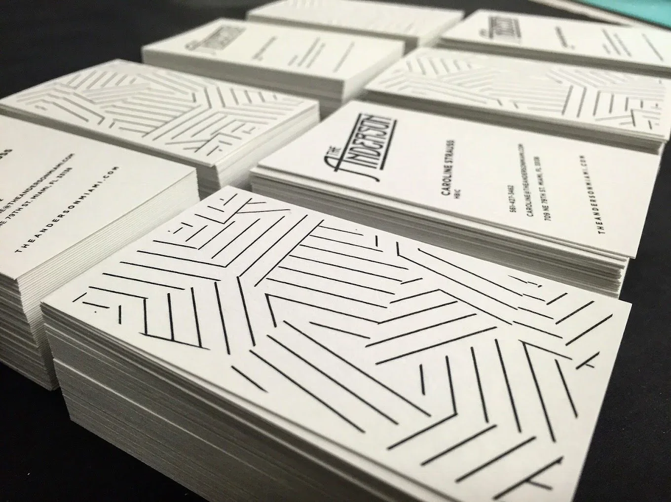 Stacks of black and white cards with geometric lines and the phrase "The Independent" on some cards, laid out on a black surface.