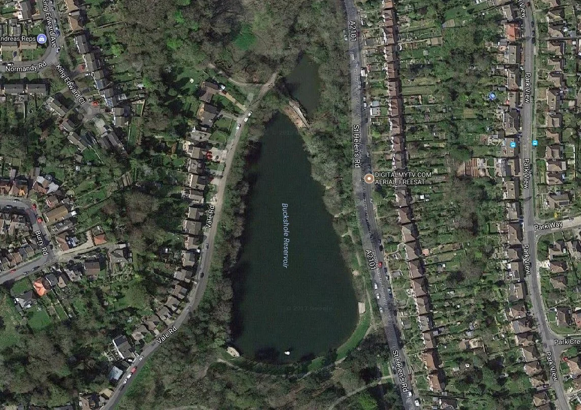 Satellite view of Buckshole Reservoir surrounded by residential houses and roads in a suburban area.