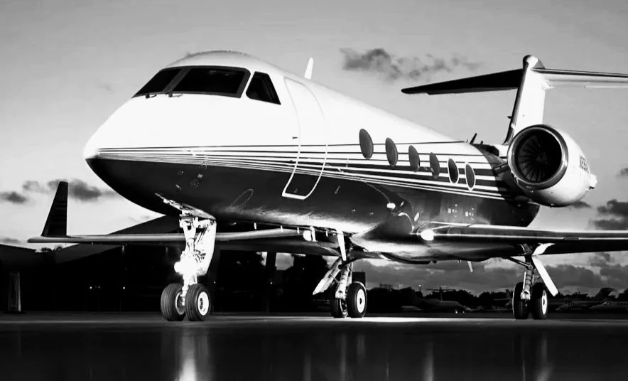 A black and white photo of a large commercial airplane parked on an airport tarmac.