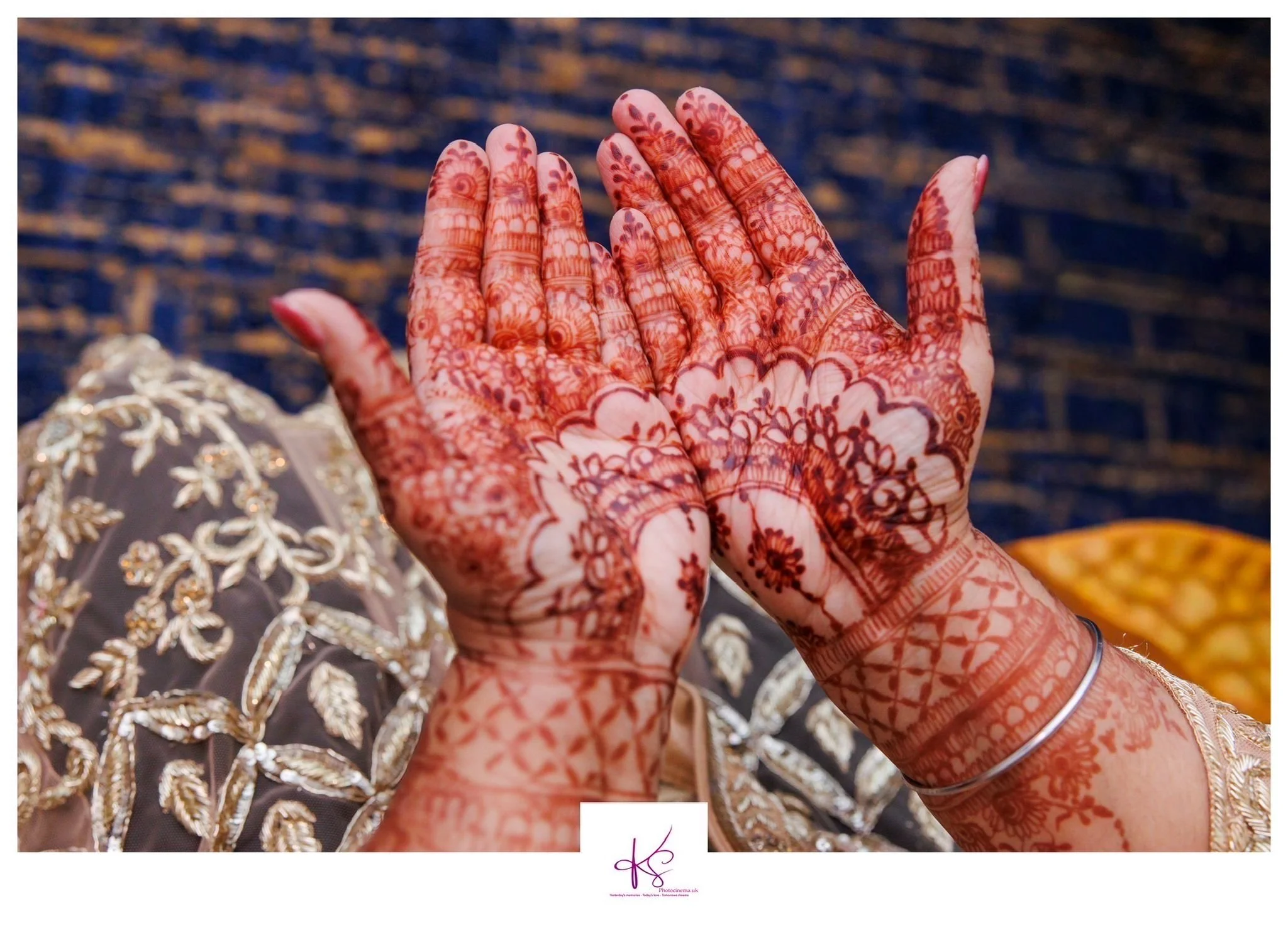 Bride palms open showing red mehndi stain on hands with intricate pattern