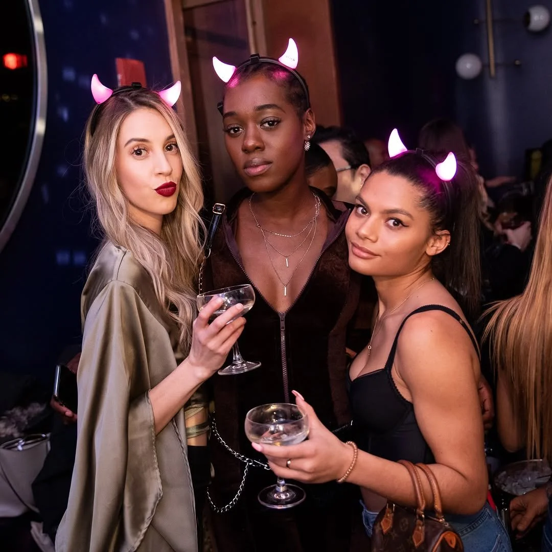 VIP group toasting champagne in costume on Halloween