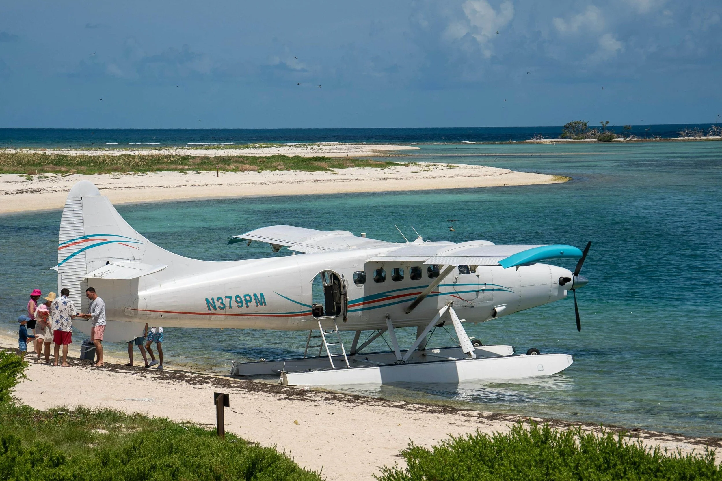 Image of a plane on a white sandy beach with blue water in the Florida keys.