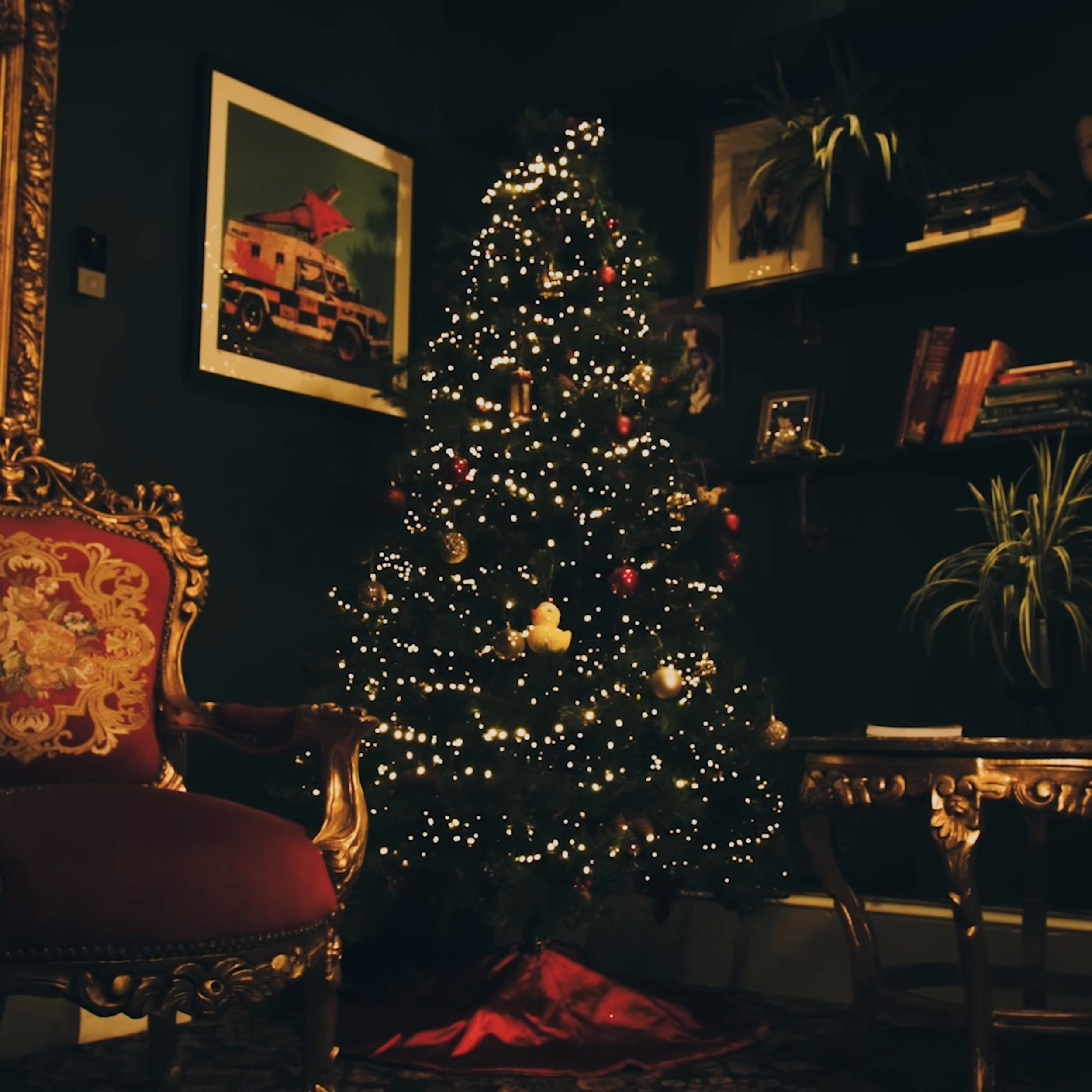 Christmas tree decorated with lights and ornaments in a cozy, dimly lit living room.