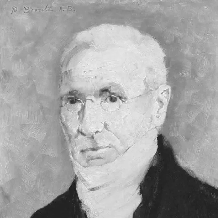Black and white portrait of an older man with glasses, white hair, and a serious expression, wearing a dark suit.
