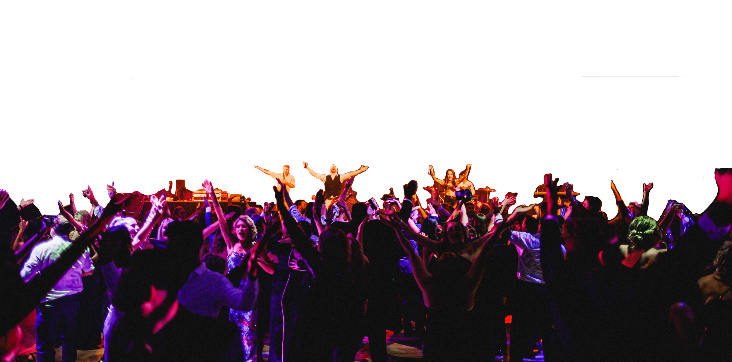 People dancing and celebrating at a lively party with a live music band performing on stage under colorful lights.